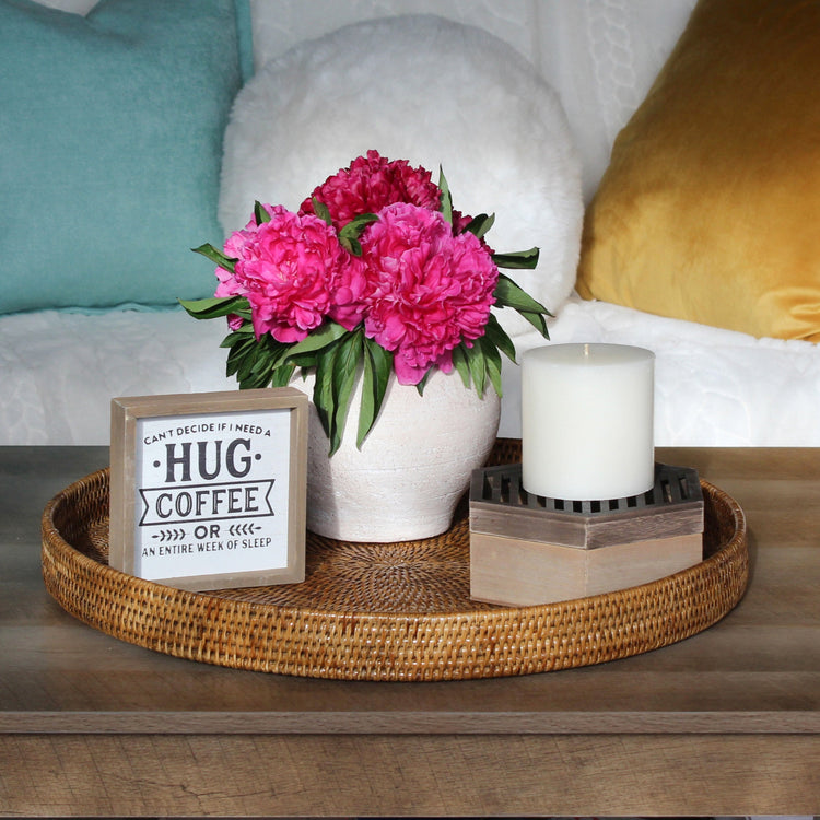 Eco Handcraft XL honey brown round rattan tray styled with flowers and candle on coffee table – sustainable home décor