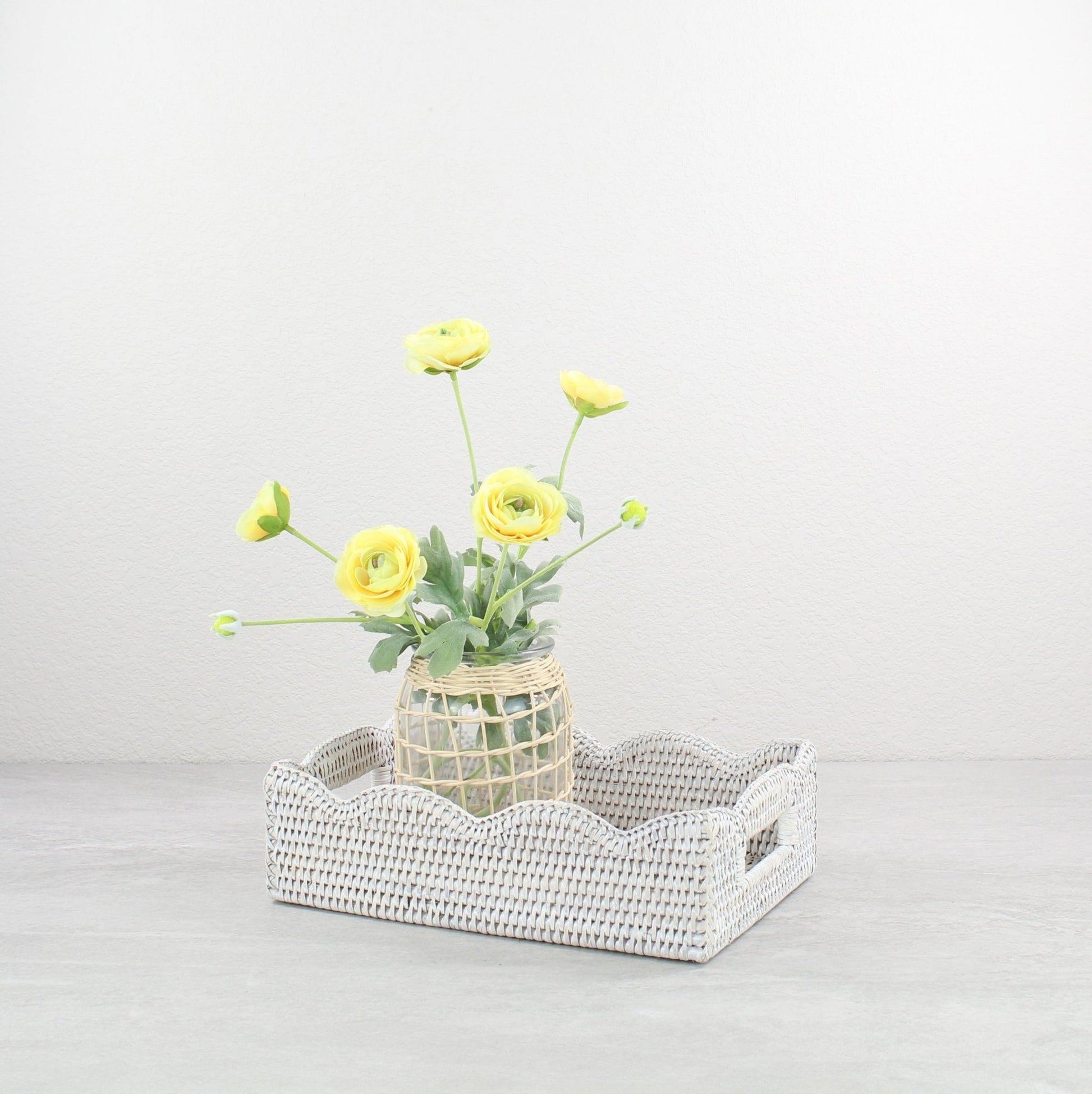 Eco Handcraft whitewash scalloped rattan tray styled with yellow floral vase for bright bathroom decor