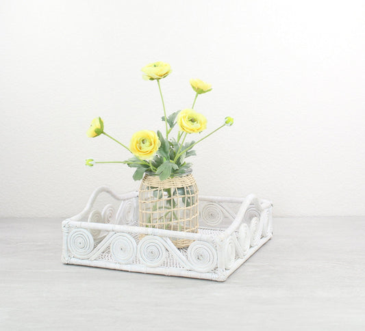 Eco Handcraft whitewash swirly rattan tray with yellow ranunculus floral arrangement for elegant spring home decor.