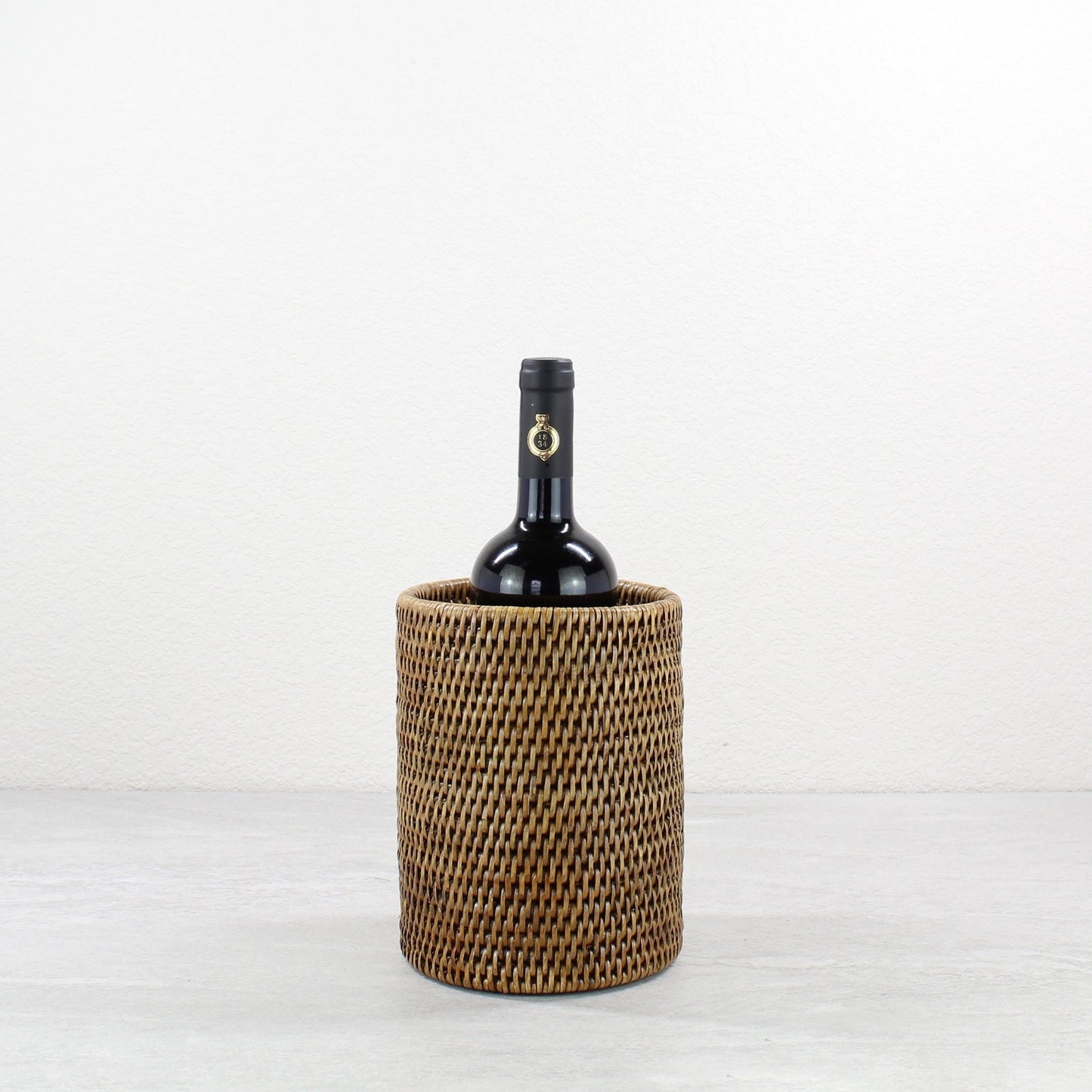 Eco-friendly handwoven rattan wine bottle holder by ECO HANDCRAFT, perfect for rustic or coastal table settings