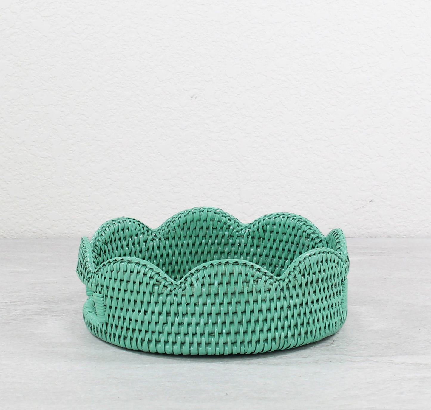 Empty tight-woven round turquoise rattan tray with scalloped edge for table centerpiece or fruit display