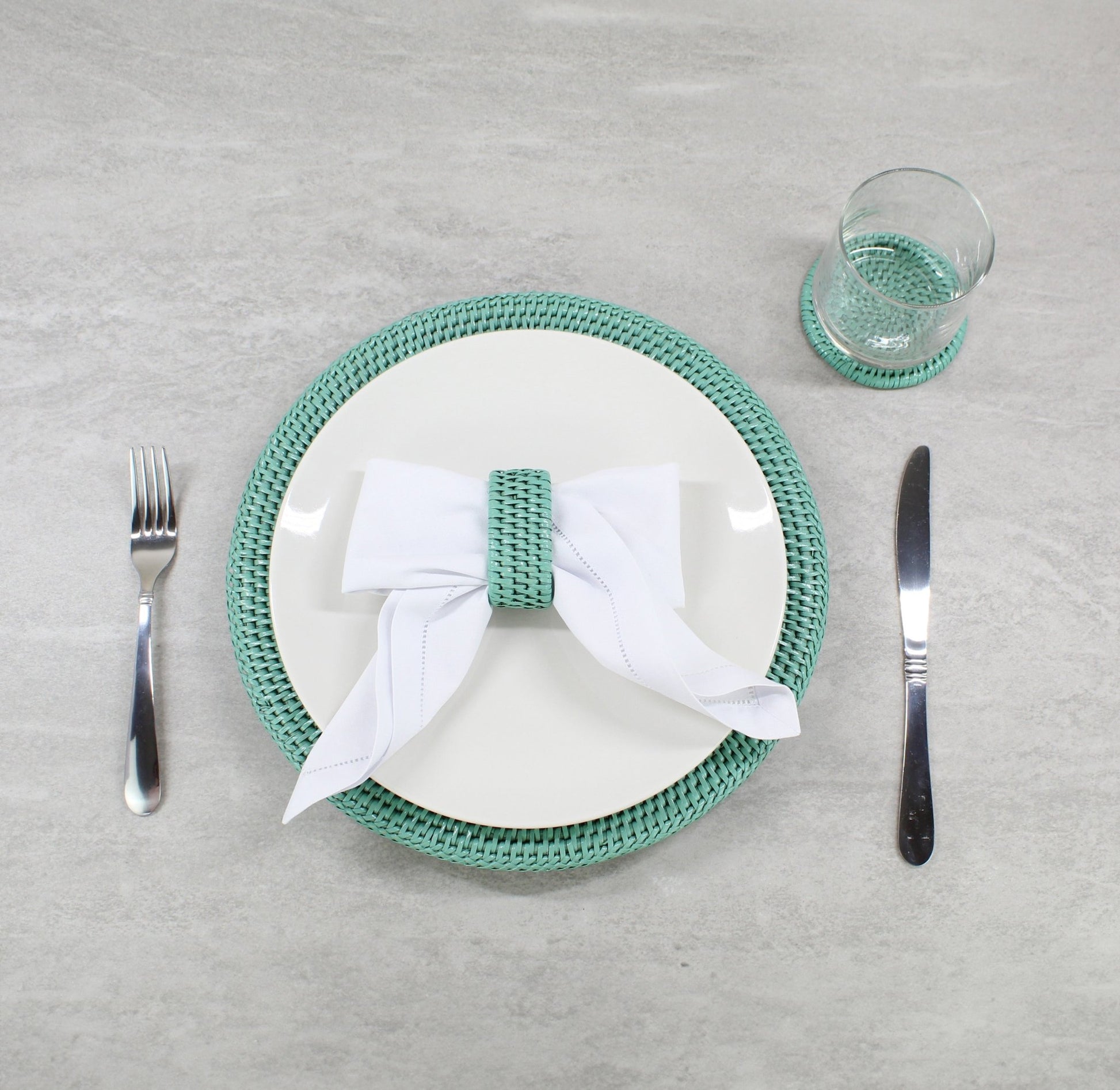 Elegant table setting with turquoise rattan charger, napkin ring, and coaster—perfect for eco-friendly dining style.