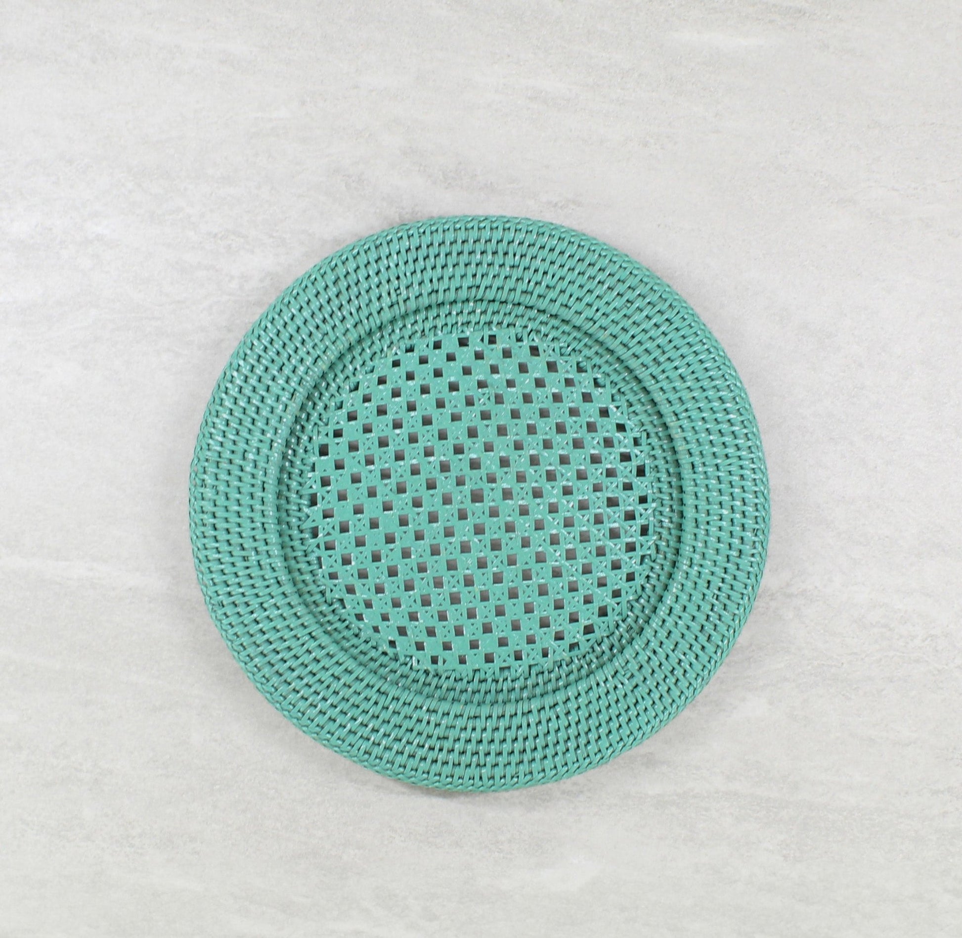 Round turquoise rattan placemat with open-weave center, handwoven for elegant and breathable table styling.