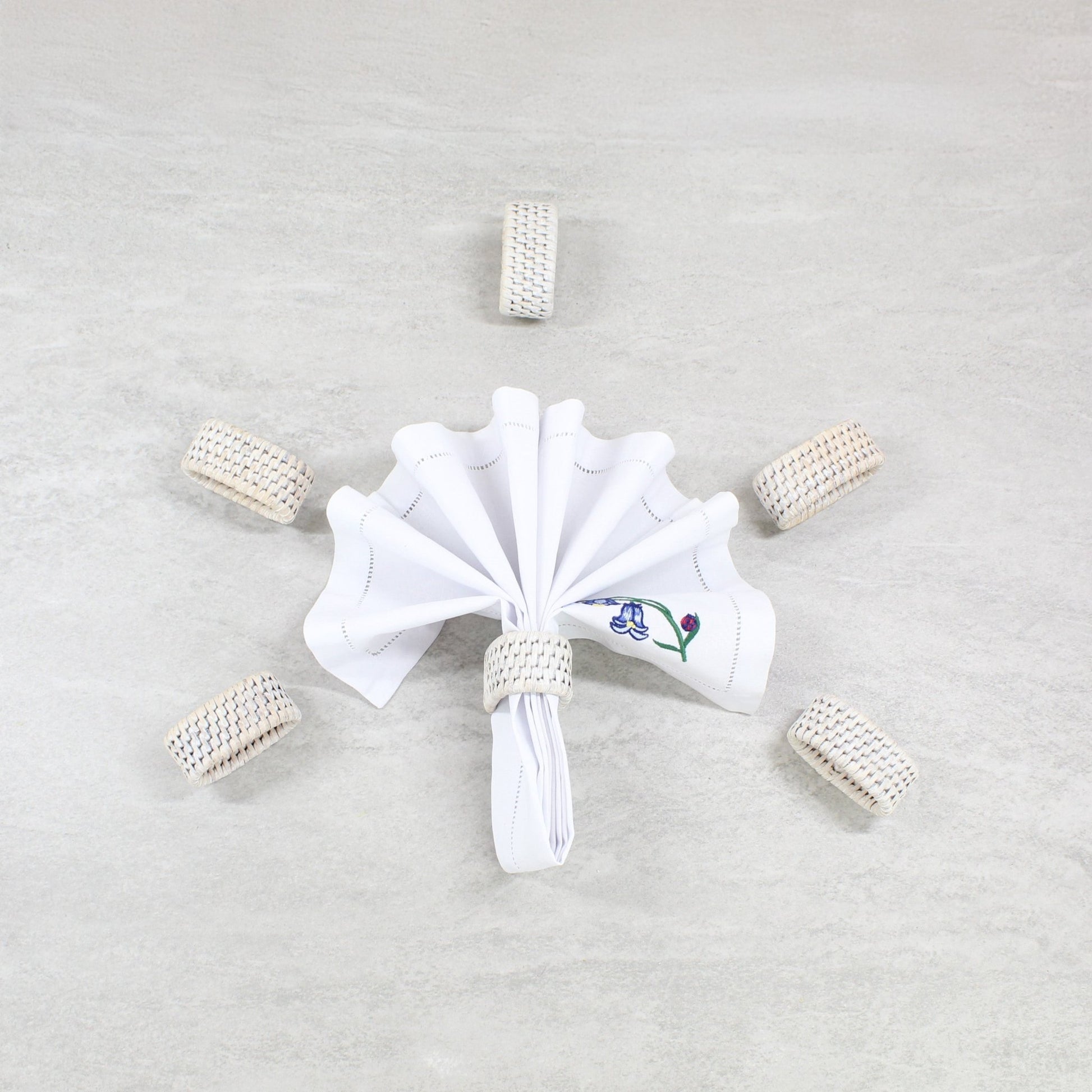 ECO HANDCRAFT whitewashed rattan napkin rings set of 6, styled with a folded cloth napkin for elegant dining décor