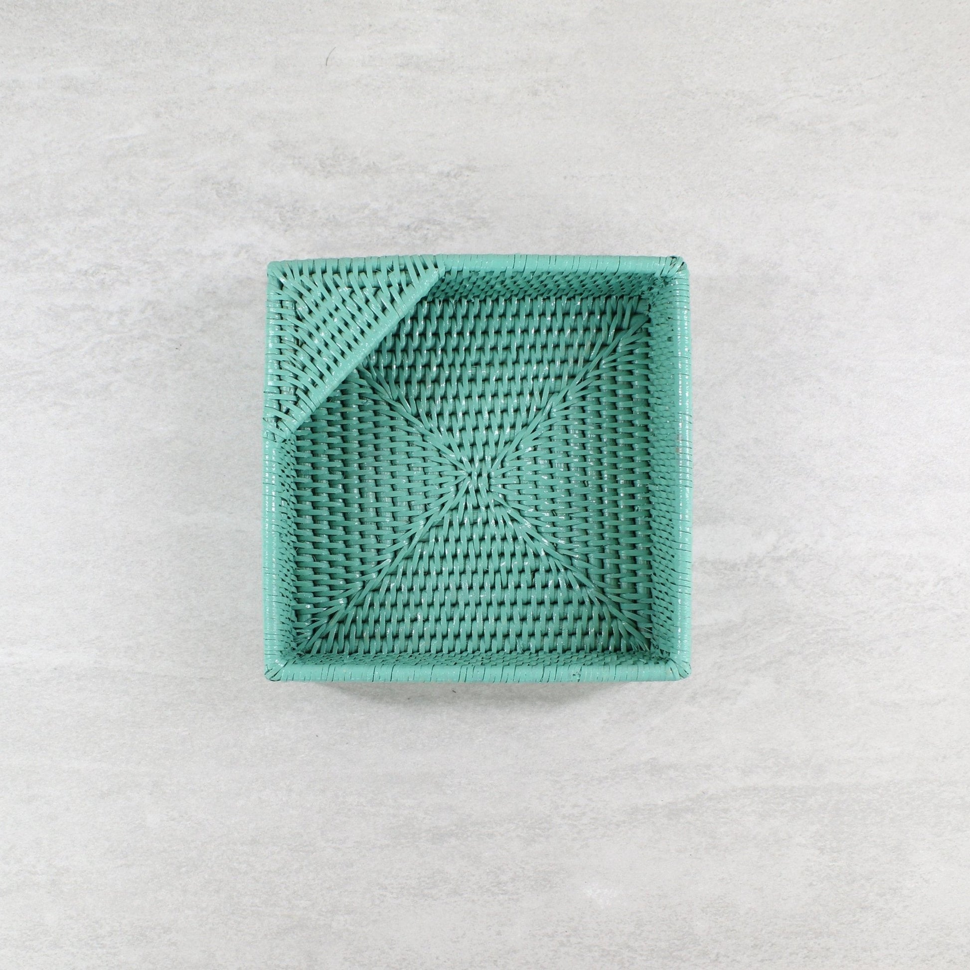 Eco Handcraft Square turquoise rattan napkin holder with tight weaving, styled flat on a light stone surface.