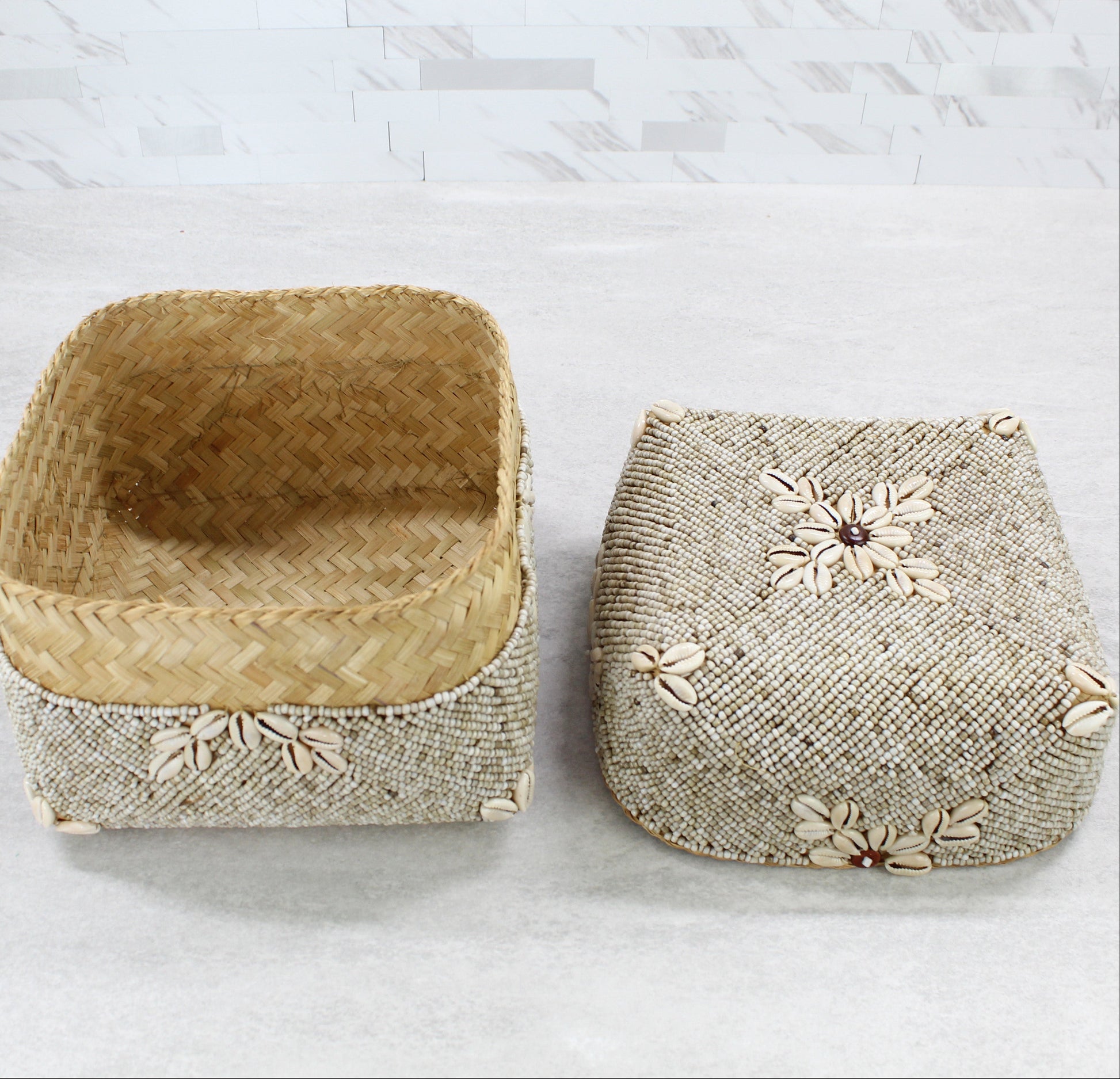 Open handmade beaded cowrie shell box showing natural rattan interior weave and matching beaded lid beside it.