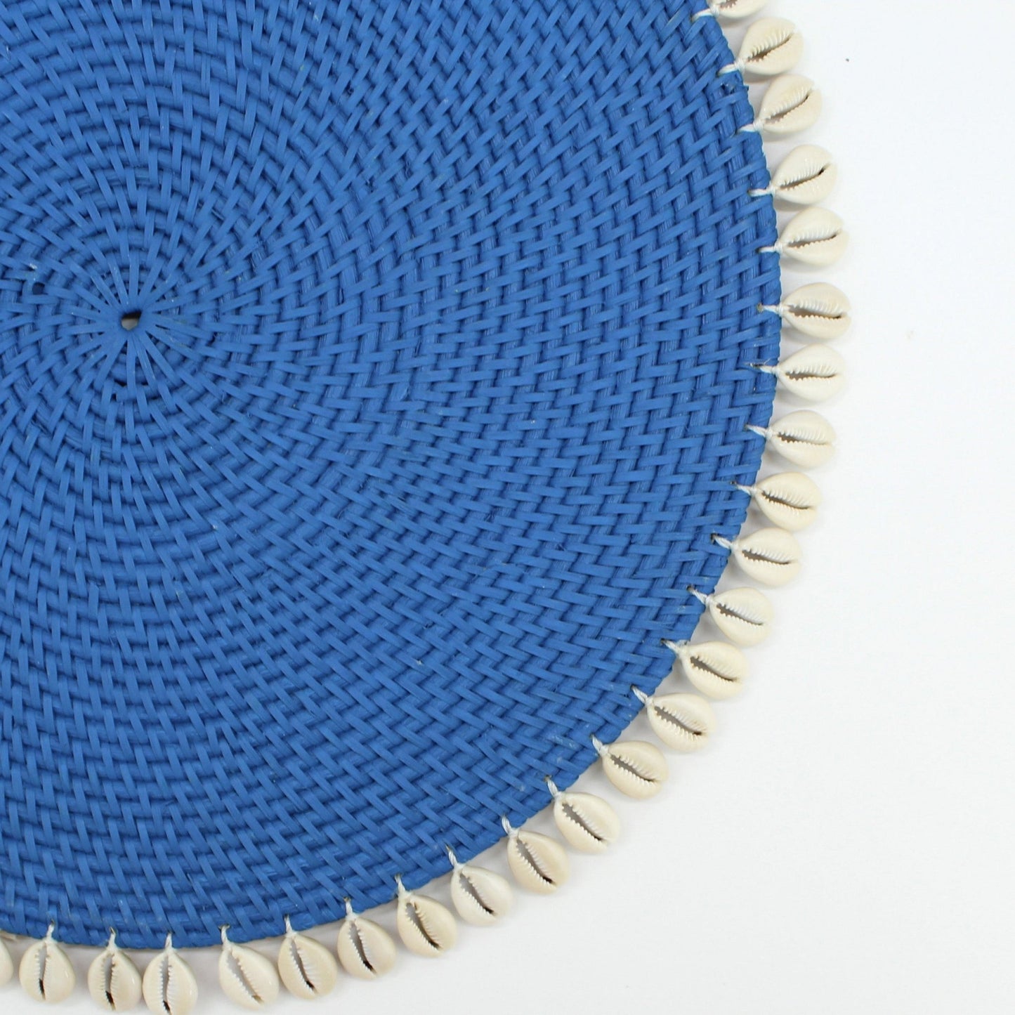 Details of blue handwoven placemat with seashells border on a white background