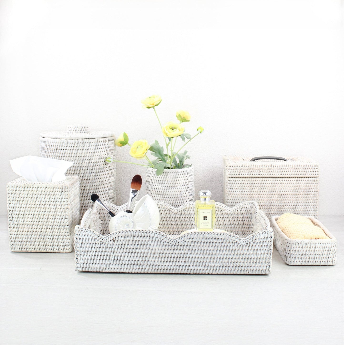 Eco Handcraft whitewash rattan bathroom set with tissue box, canister, scalloped tray, and organizer, styled with yellow flowers