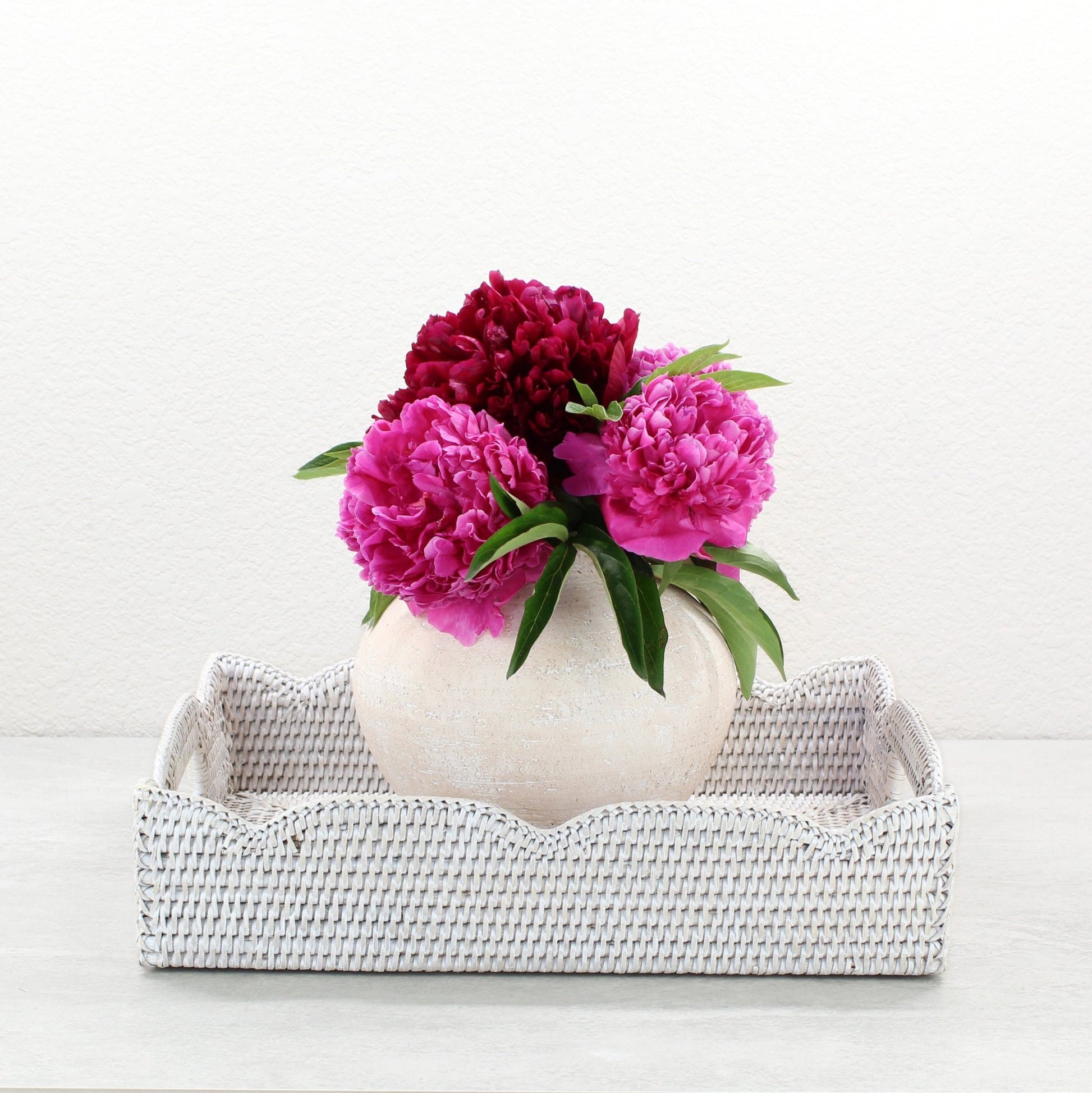Eco Handcraft whitewash scalloped rattan tray styled with round vase and pink peonies