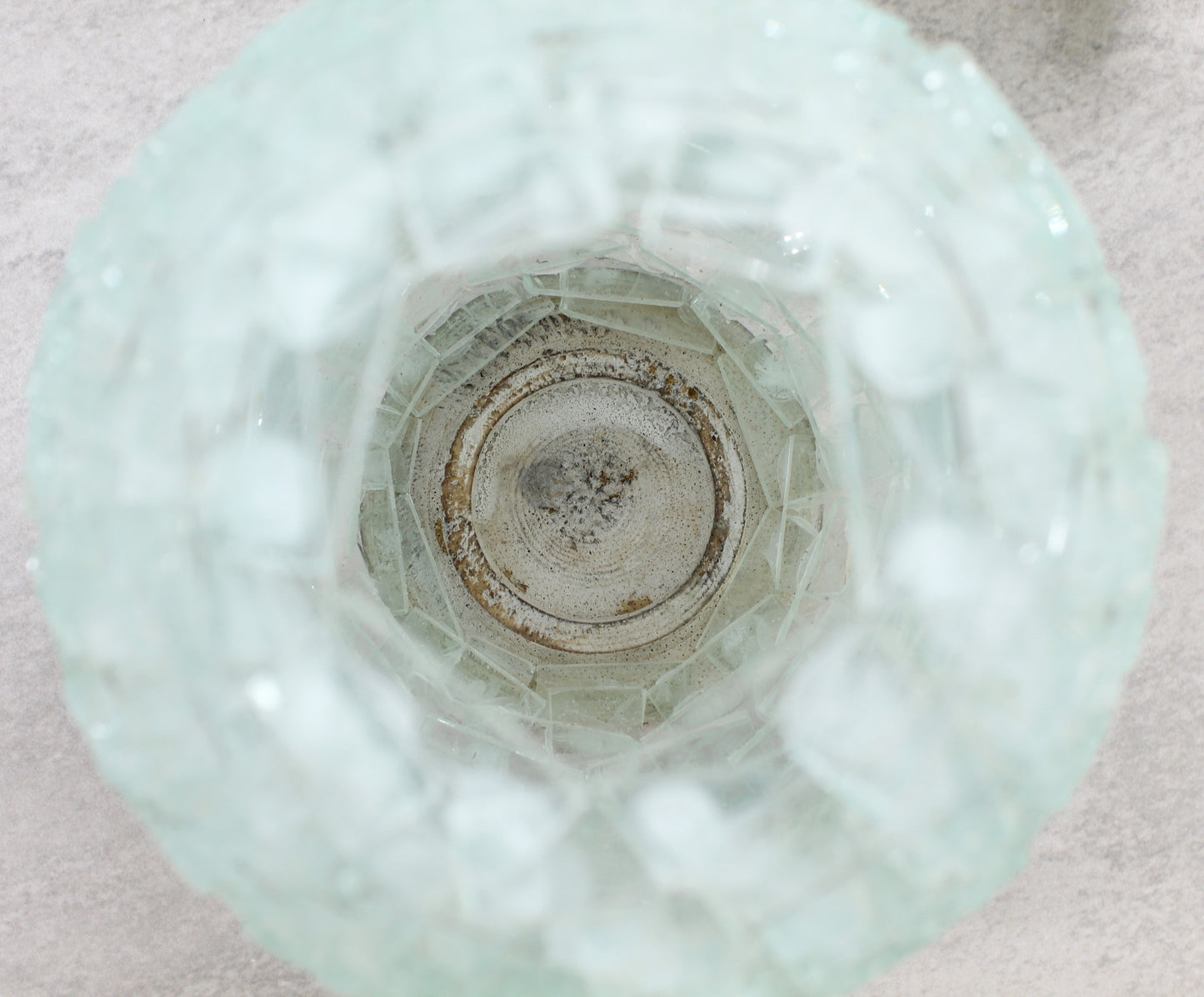 Close-up of the handmade pineapple glass tea light holder interior showing natural wood base and layered glass craftsmanship for light reflection.