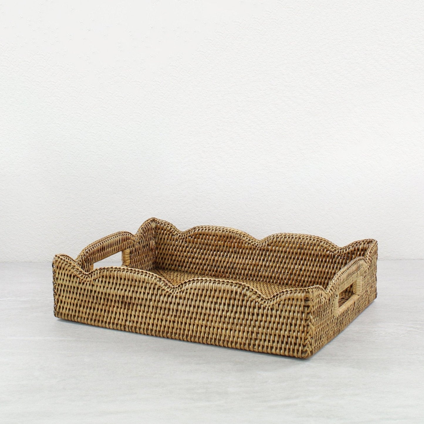 Handwoven scalloped rectangle rattan tray in honey brown, eco-friendly storage and serving tray with decorative wavy edges.