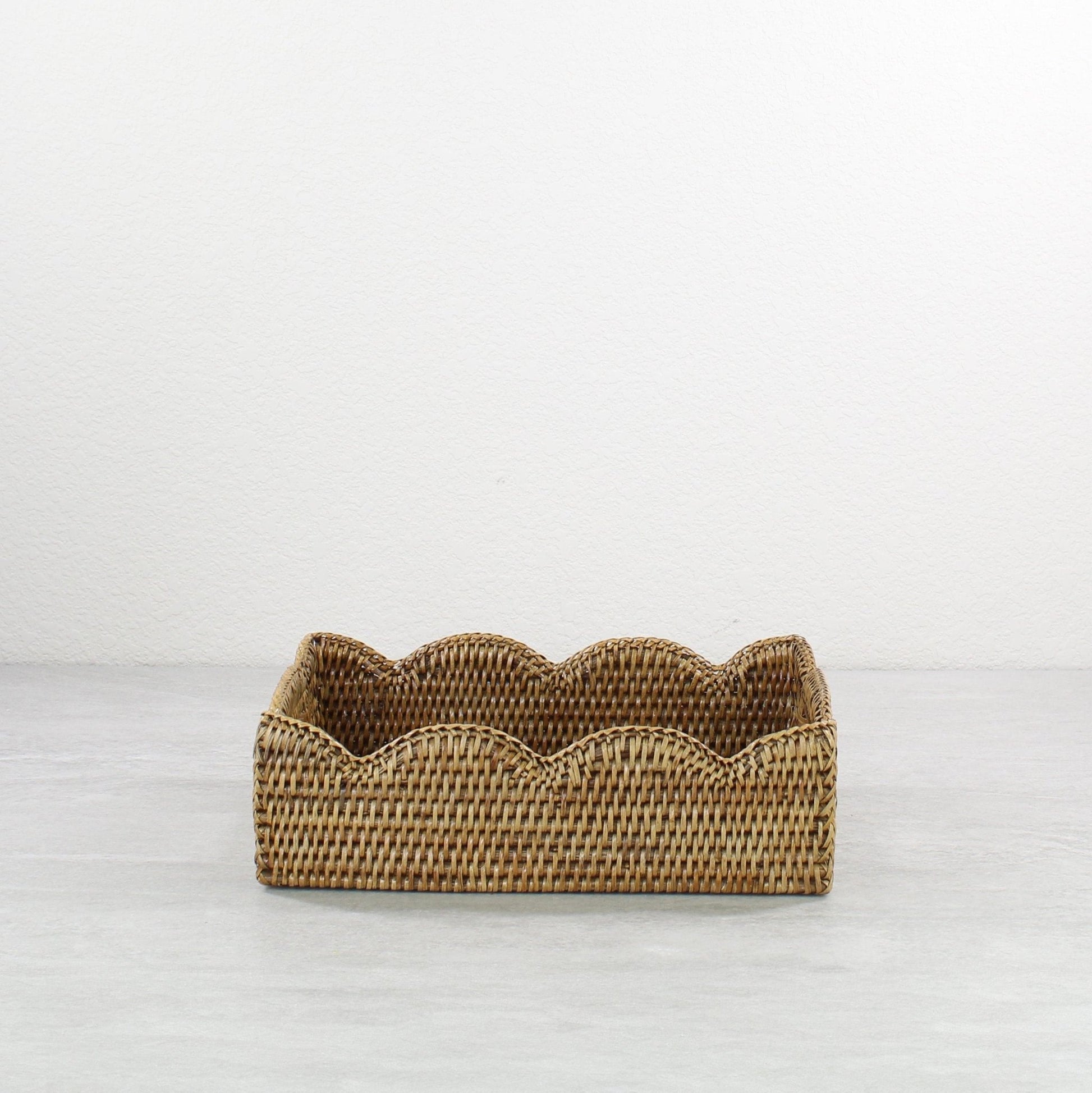 Front view of scalloped edge rattan tray in honey brown, rectangular eco-friendly handmade tray with wavy decorative border.