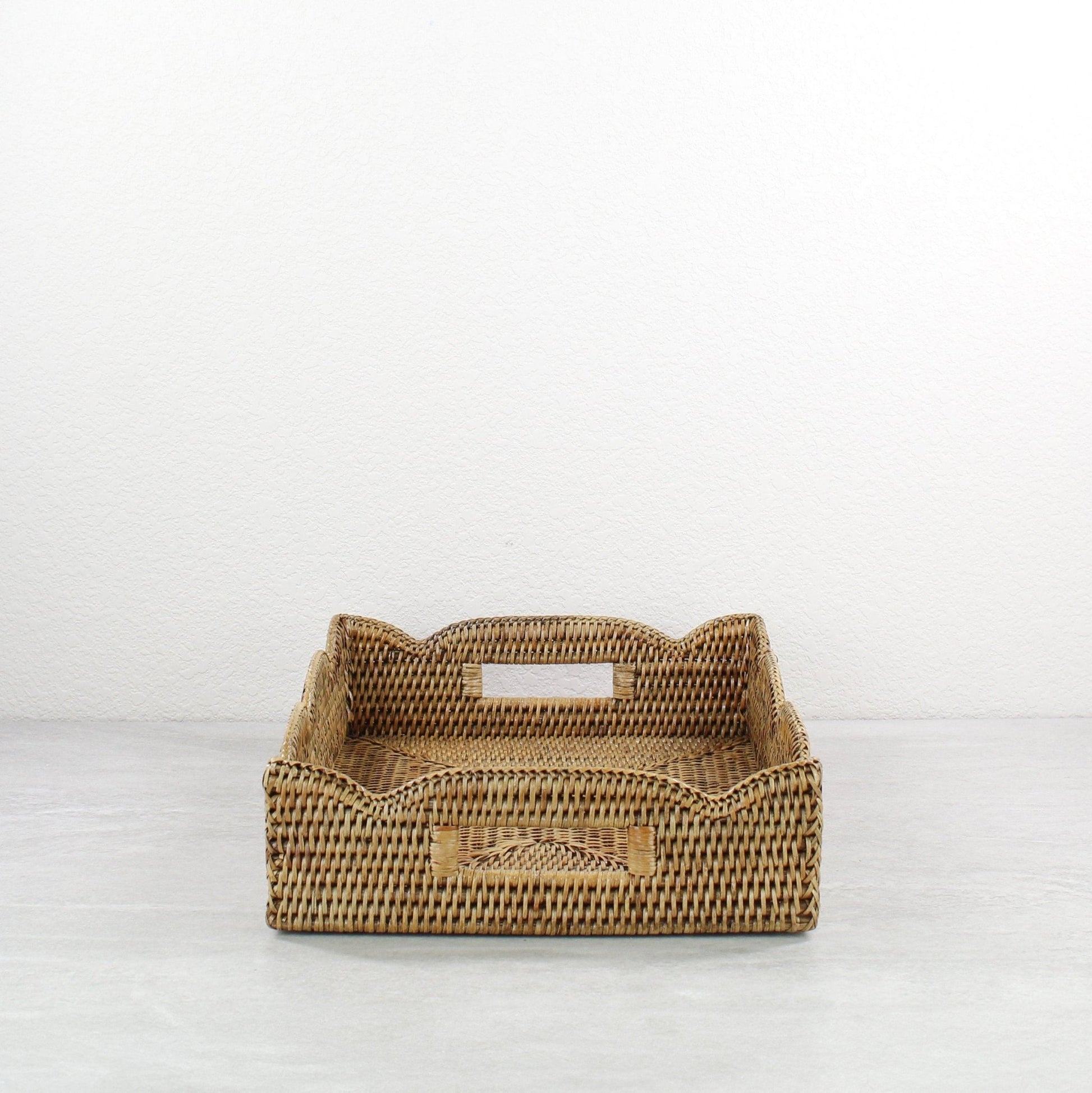 Scalloped rectangle rattan tray in honey brown with built-in side handles, handmade from durable natural rattan for easy carrying and serving.