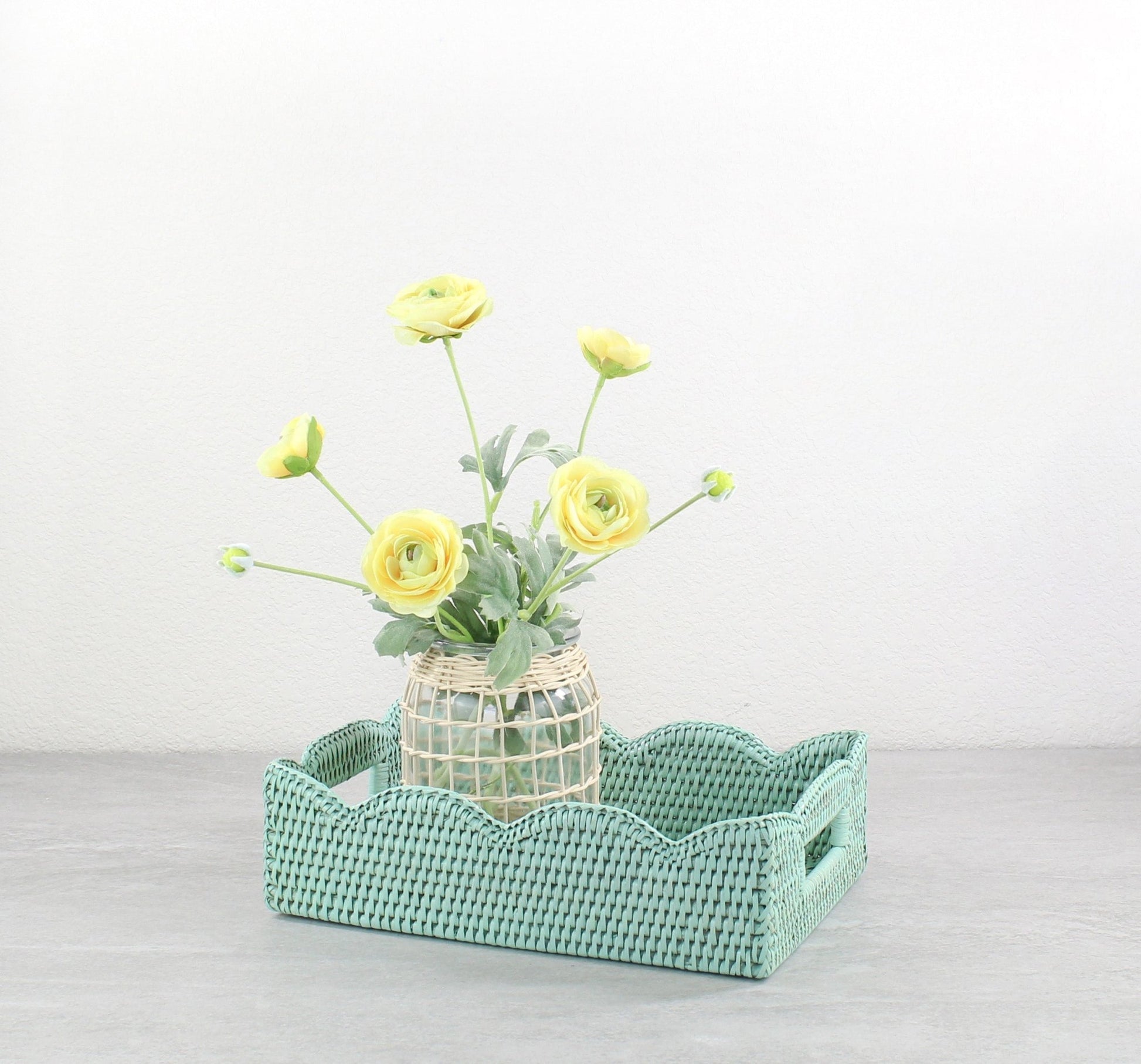 ECO HANDCRAFT rectangular sage green rattan tray with scalloped edges styled with yellow flowers for spring home décor