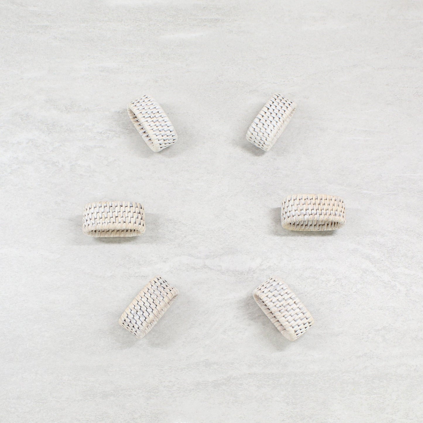 Eco Handcraft handmade whitewash oval rattan napkin rings placed on a table