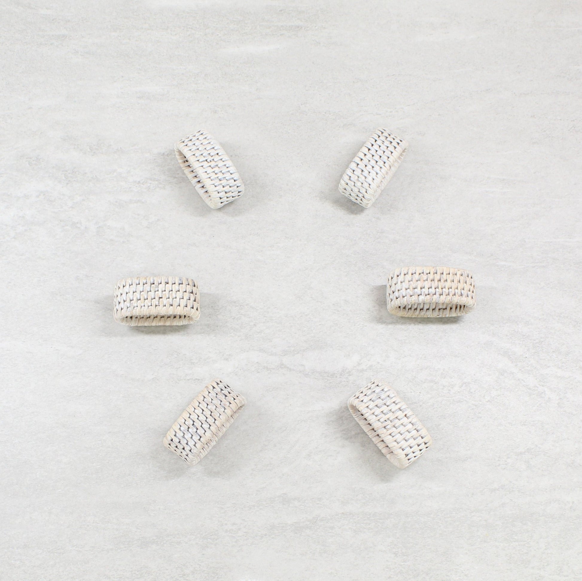 Eco Handcraft handmade whitewash oval rattan napkin rings placed on a table