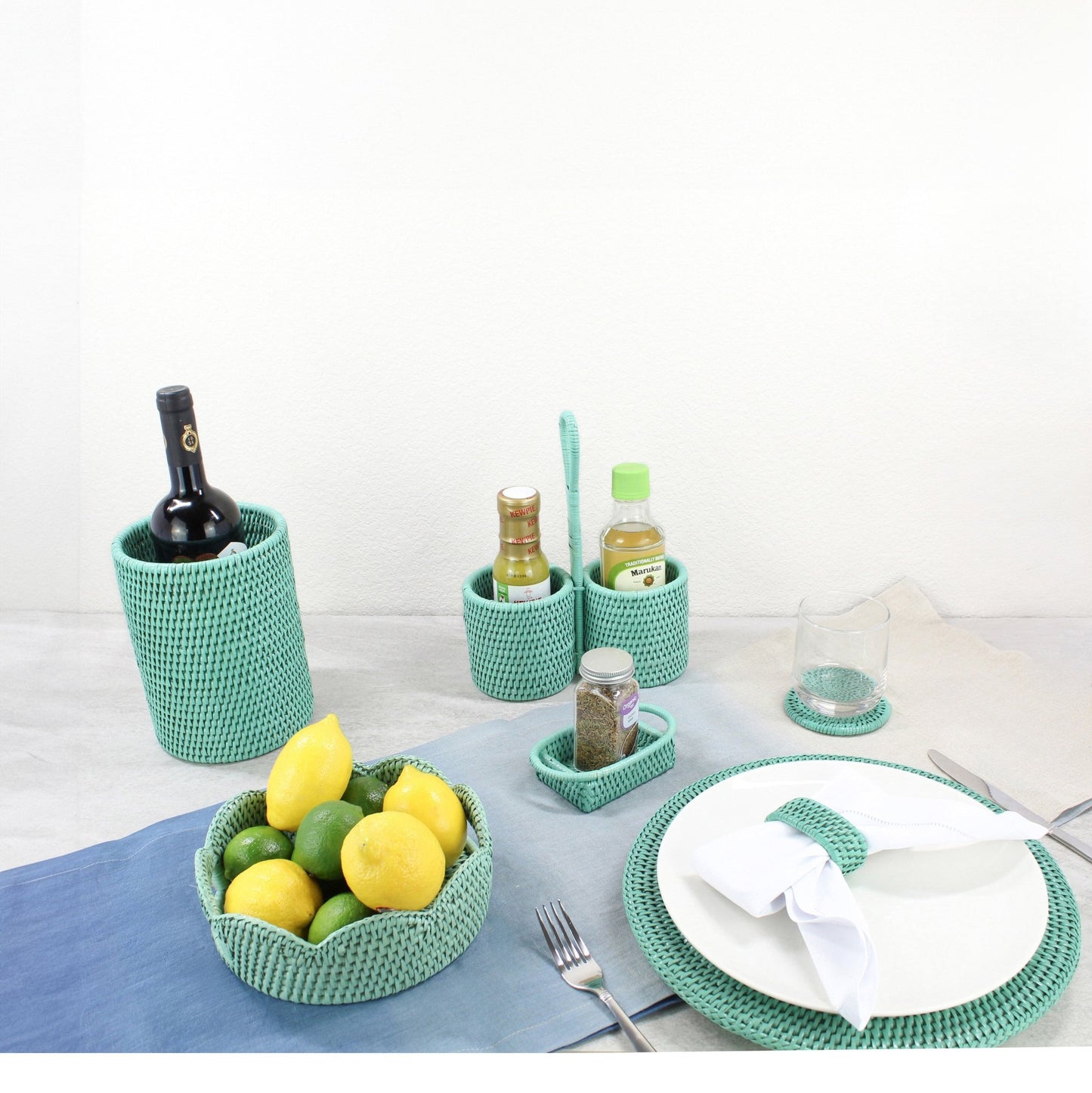 Eco-friendly rattan dining accessories by ECO HANDCRAFT in turquoise, styled for modern sustainable table setting.