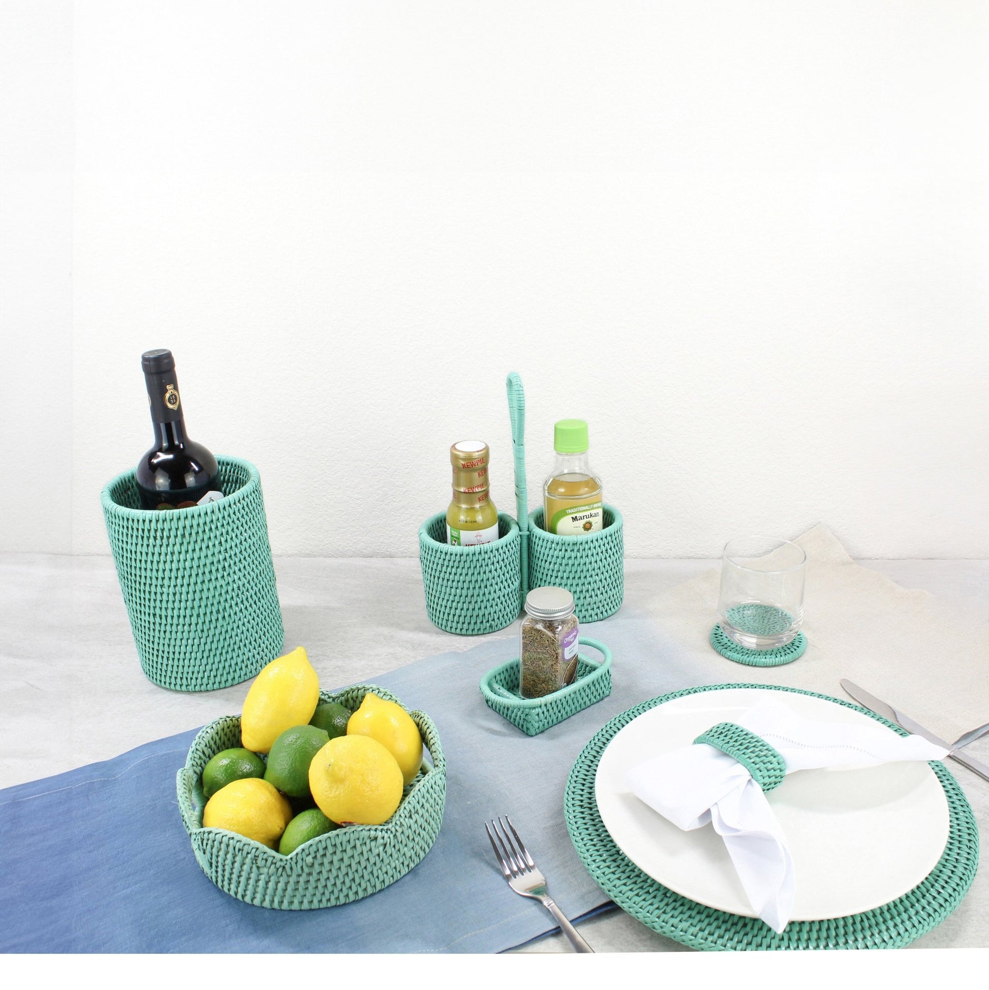 Eco-friendly rattan dining accessories by ECO HANDCRAFT in turquoise, styled for modern sustainable table setting.