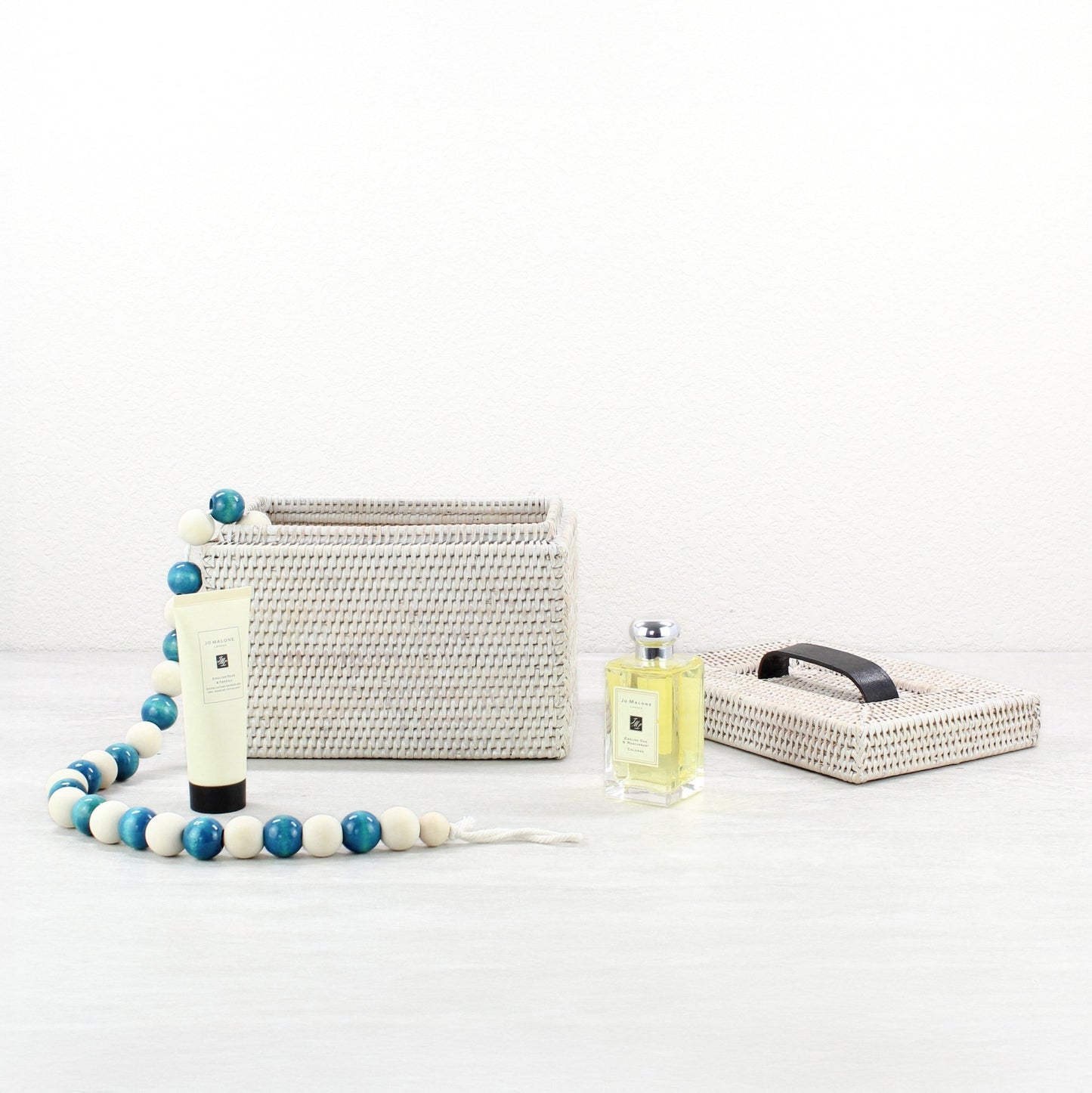 ECO HANDCRAFT handmade whitewash rattan storage box with lid, styled with lotion, perfume, and wood bead garland