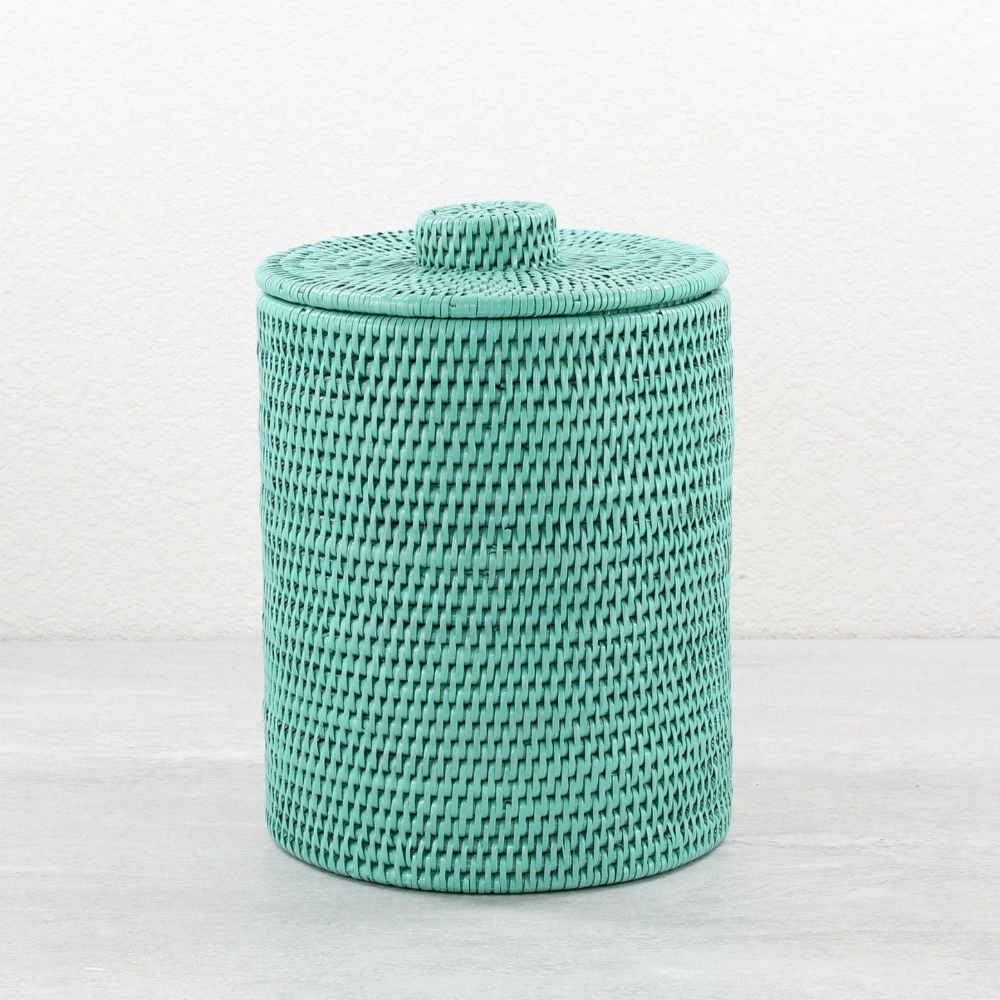 Turquoise round rattan waste bin with lid, tightly woven and handmade, shown on white background for product display.