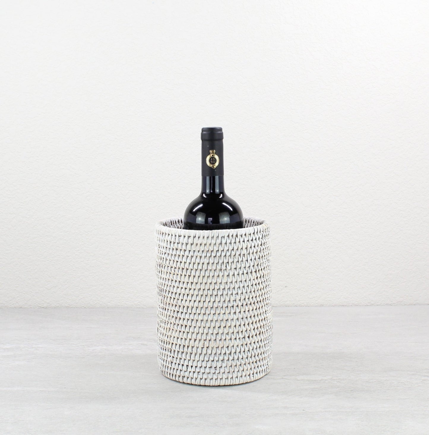 Tight woven rattan wine bottle holder in whitewash finish, perfect for beach weddings, rustic parties, or modern bars