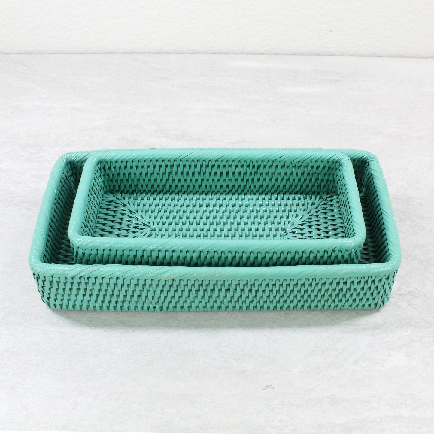 Set of two rectangular turquoise rattan trays nested together with fine woven texture