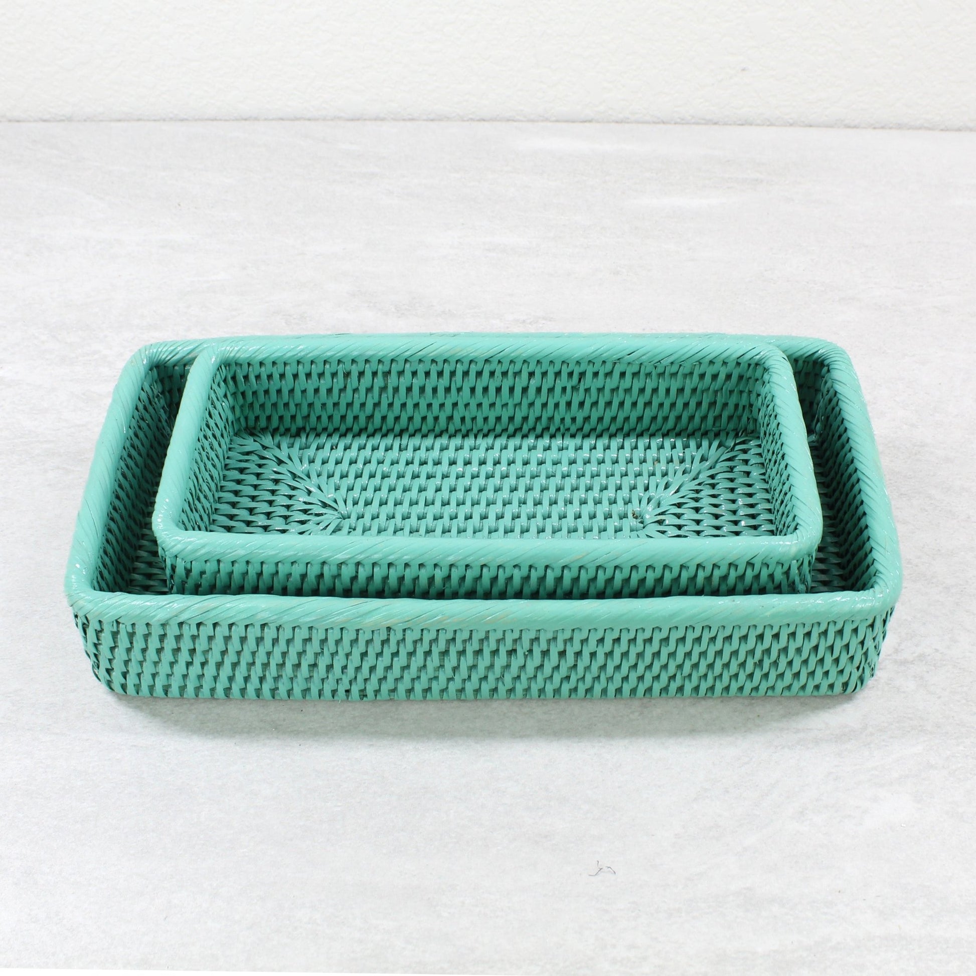 Set of two rectangular turquoise rattan trays nested together with fine woven texture