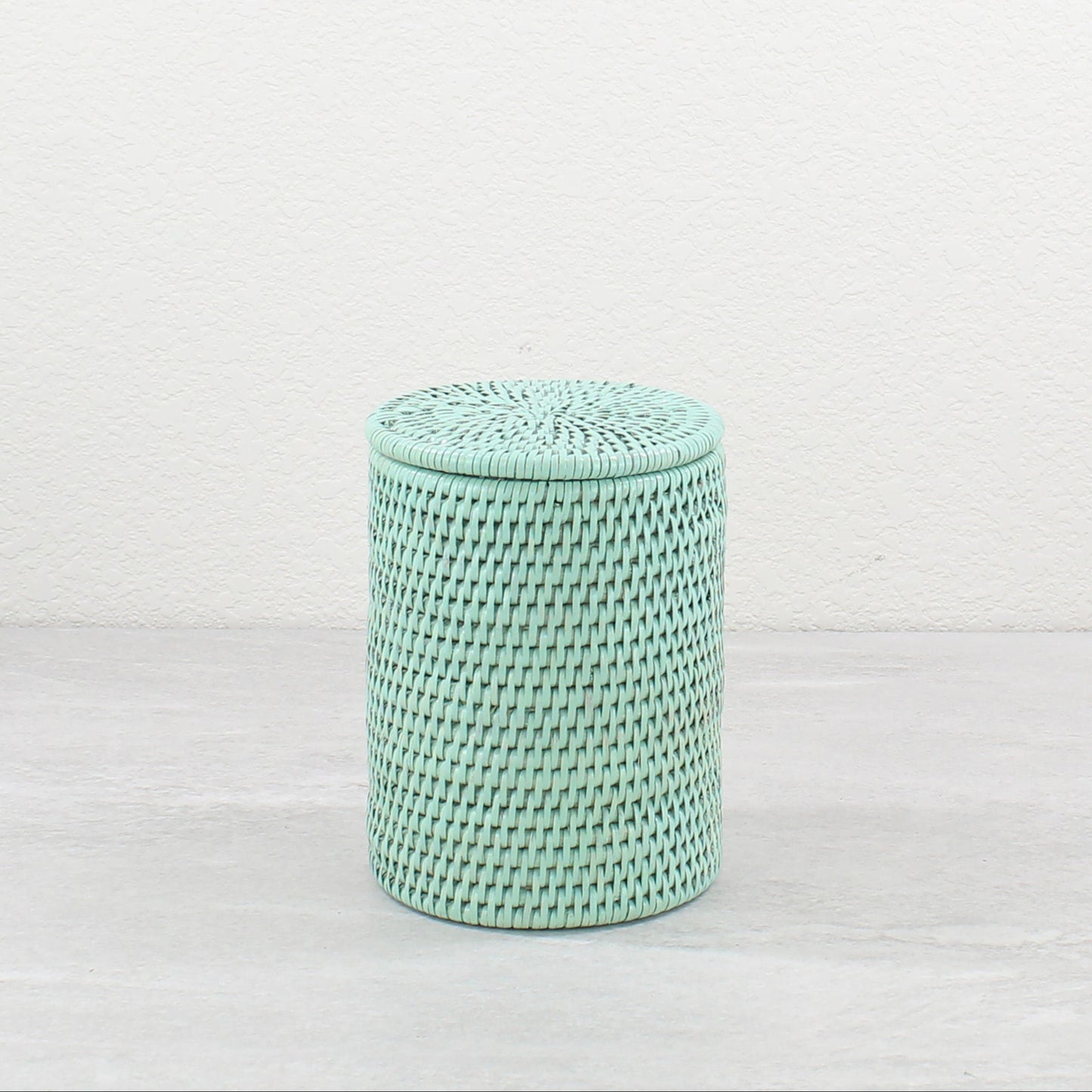 Sage leaf green rattan canister with lid on, eco-friendly storage for bathroom or kitchen countertops