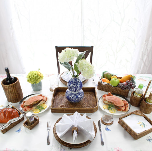 ECO HANDCRAFT honey brown rattan dining set styled with seafood, fruit, and flowers for elegant coastal table décor