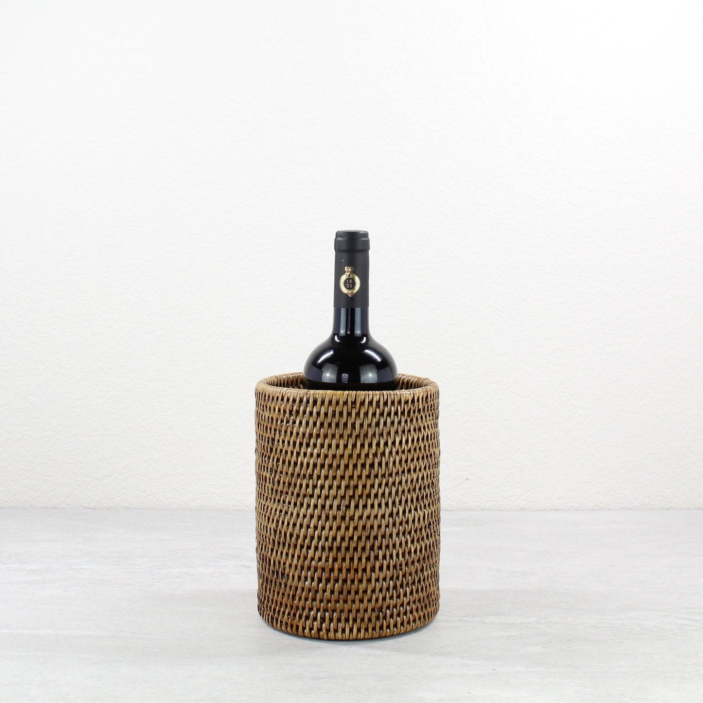 ECO HANDCRAFT brown rattan wine bottle holder, handcrafted for eco-friendly entertaining and rustic table style.