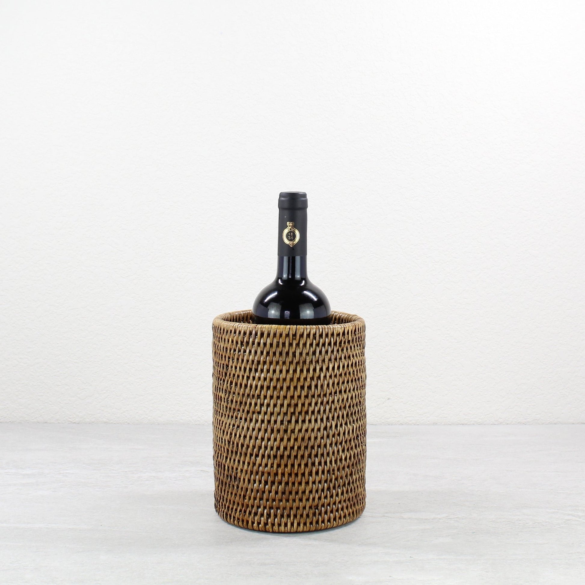 Rattan wine bottle holder in honey brown for rustic bar decor or entertaining table styling