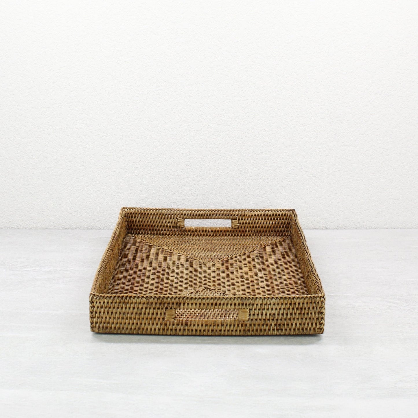 Side view of honey brown rattan tray edge showing detailed tight weave and durable handcrafted construction.