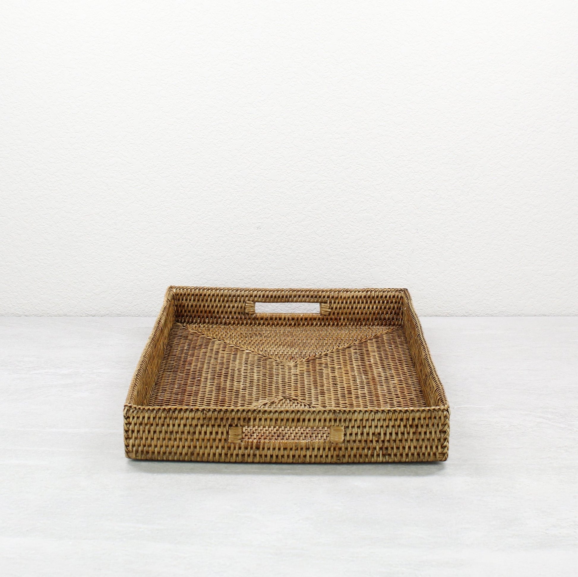 Side view of honey brown rattan tray edge showing detailed tight weave and durable handcrafted construction.