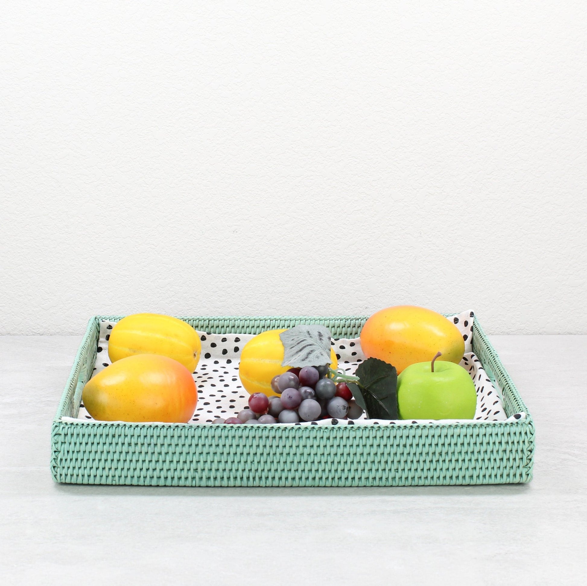 Sage Leaf woven rattan tray filled with fresh fruits on kitchen island, blending utility with natural texture.