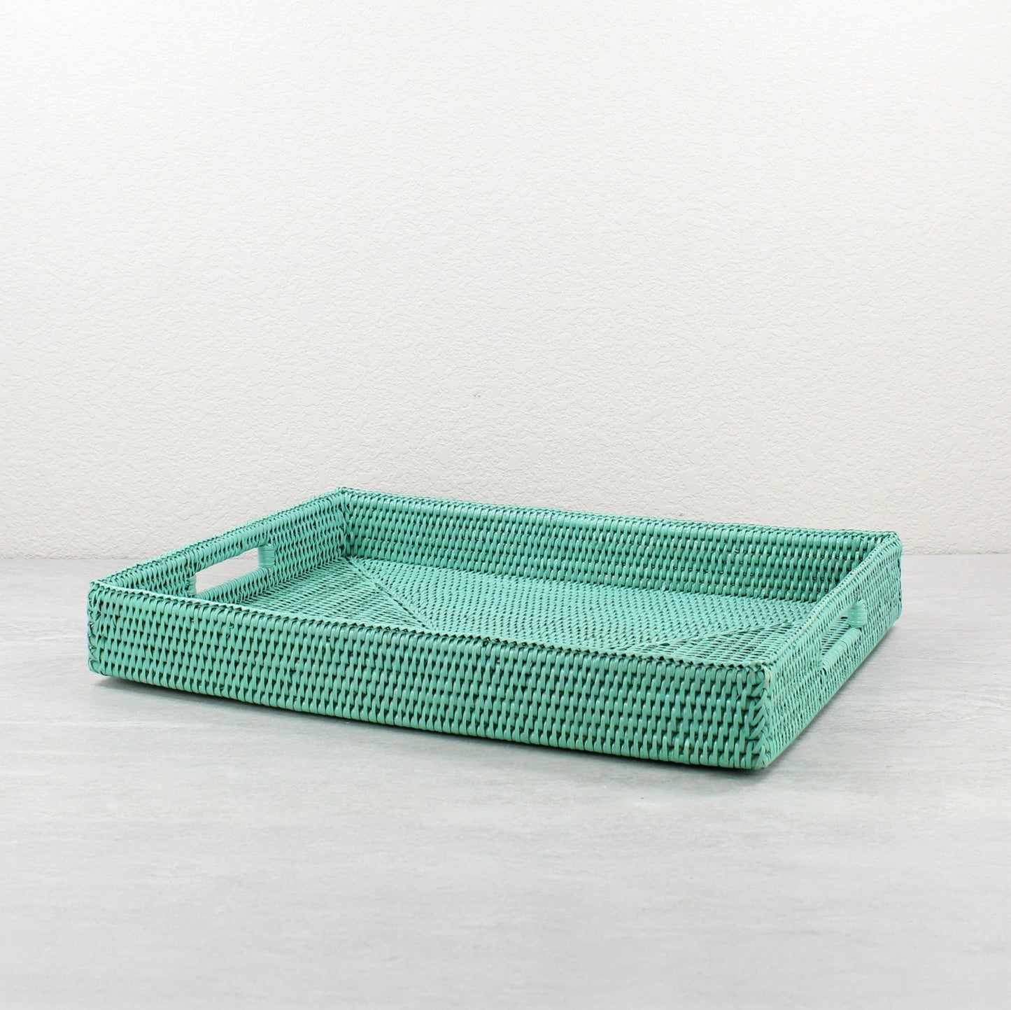 Large sage leaf rattan tray with handles and tight weave, shown on white background for clean product display.