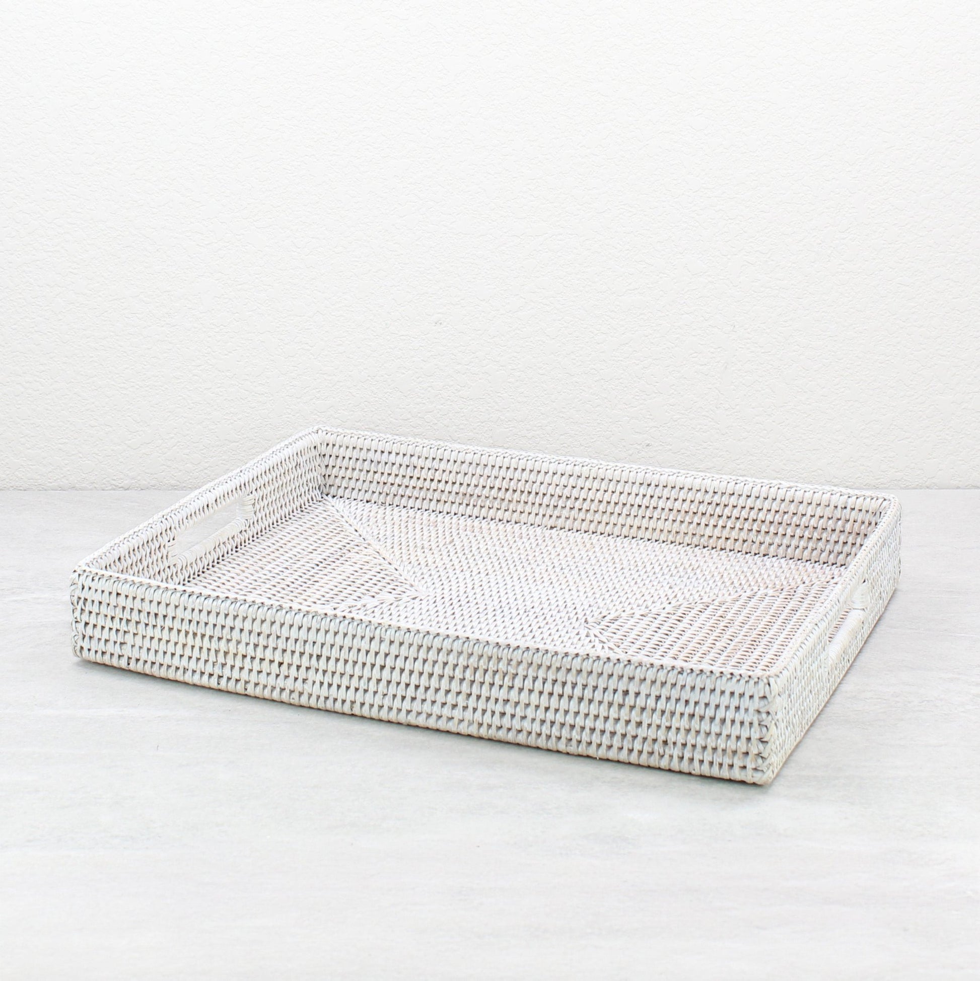 Large whitewash rattan tray with handles and tight weave, shown on white background for clean product display.