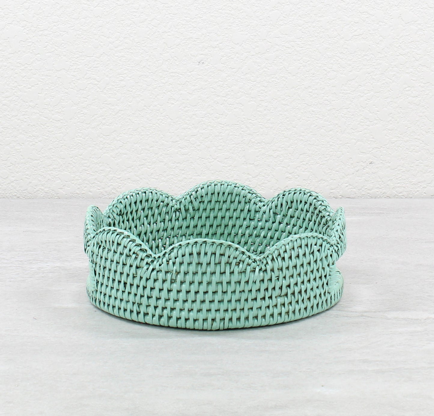 Sage Leaf Green handwoven rattan tray with scalloped edge on a light gray background
