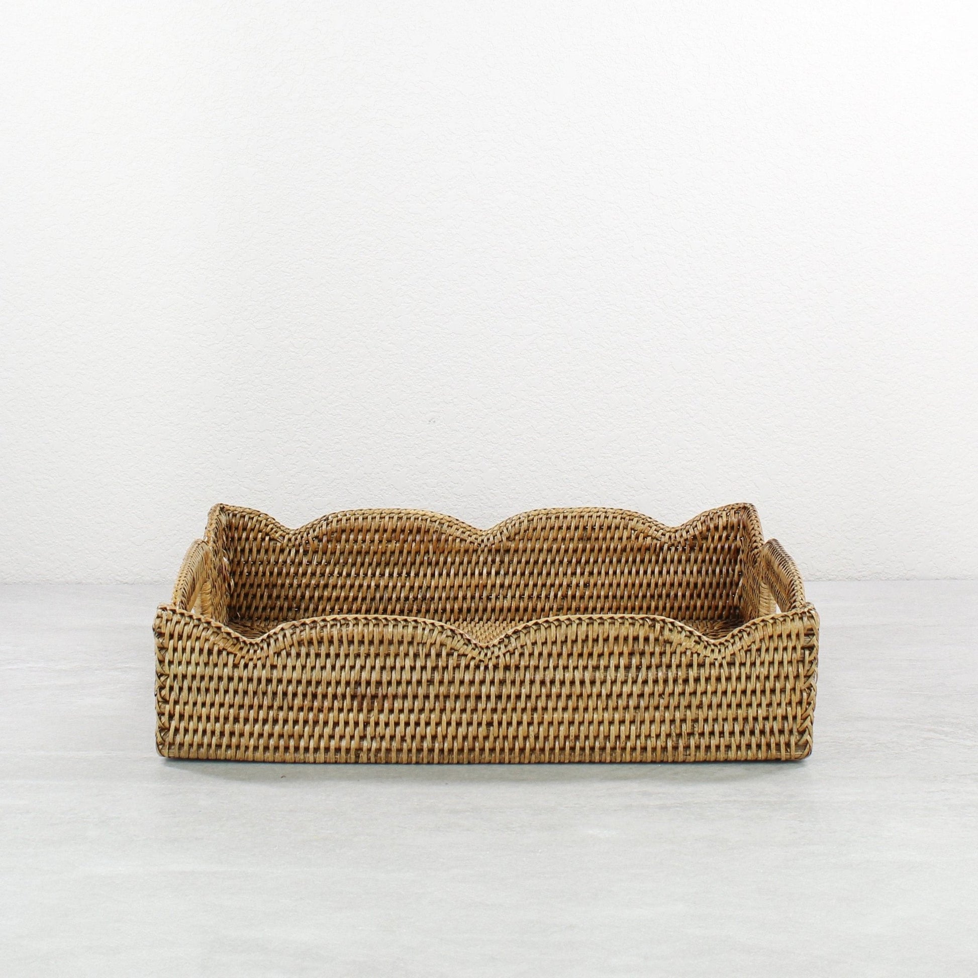 Honey brown medium scalloped rattan tray with handles on a white background, showing handwoven detail, front view.