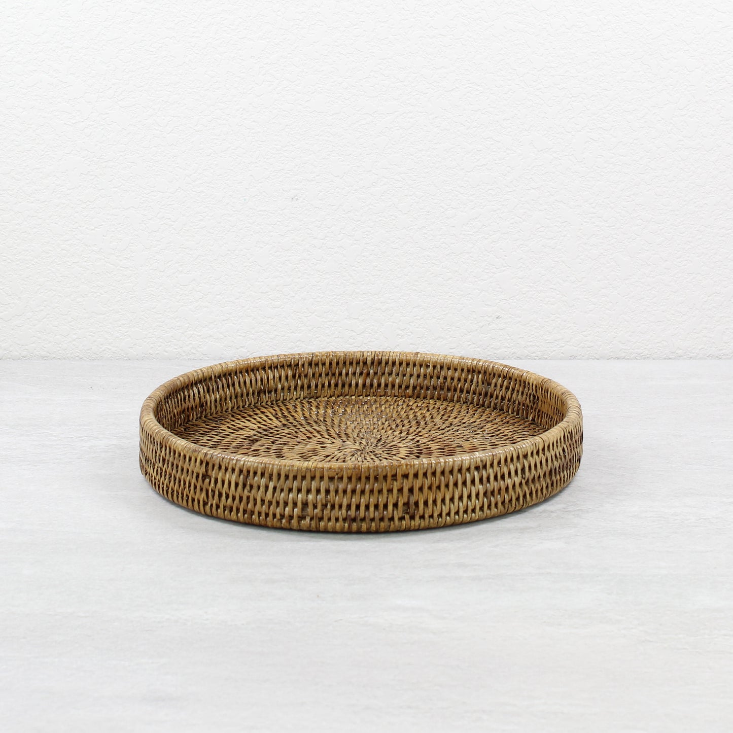 Eco Handcraft honey brown round rattan tray, 12-inch tightly woven design, ideal for serving, organizing, or styling sustainable home décor.
