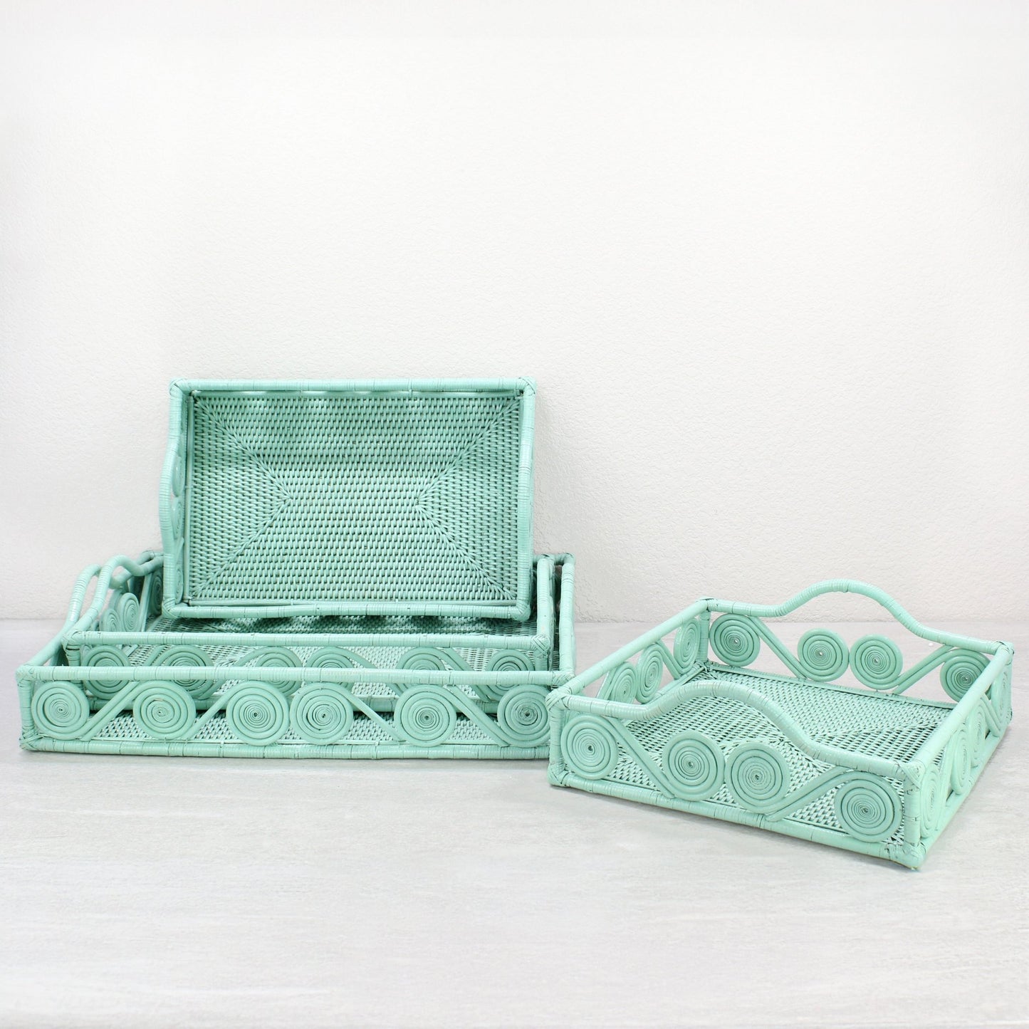 Set of Sage Leaf Green rectangular rattan trays with swirl design, displayed in multiple sizes for luxury mid-century modern home organizing.