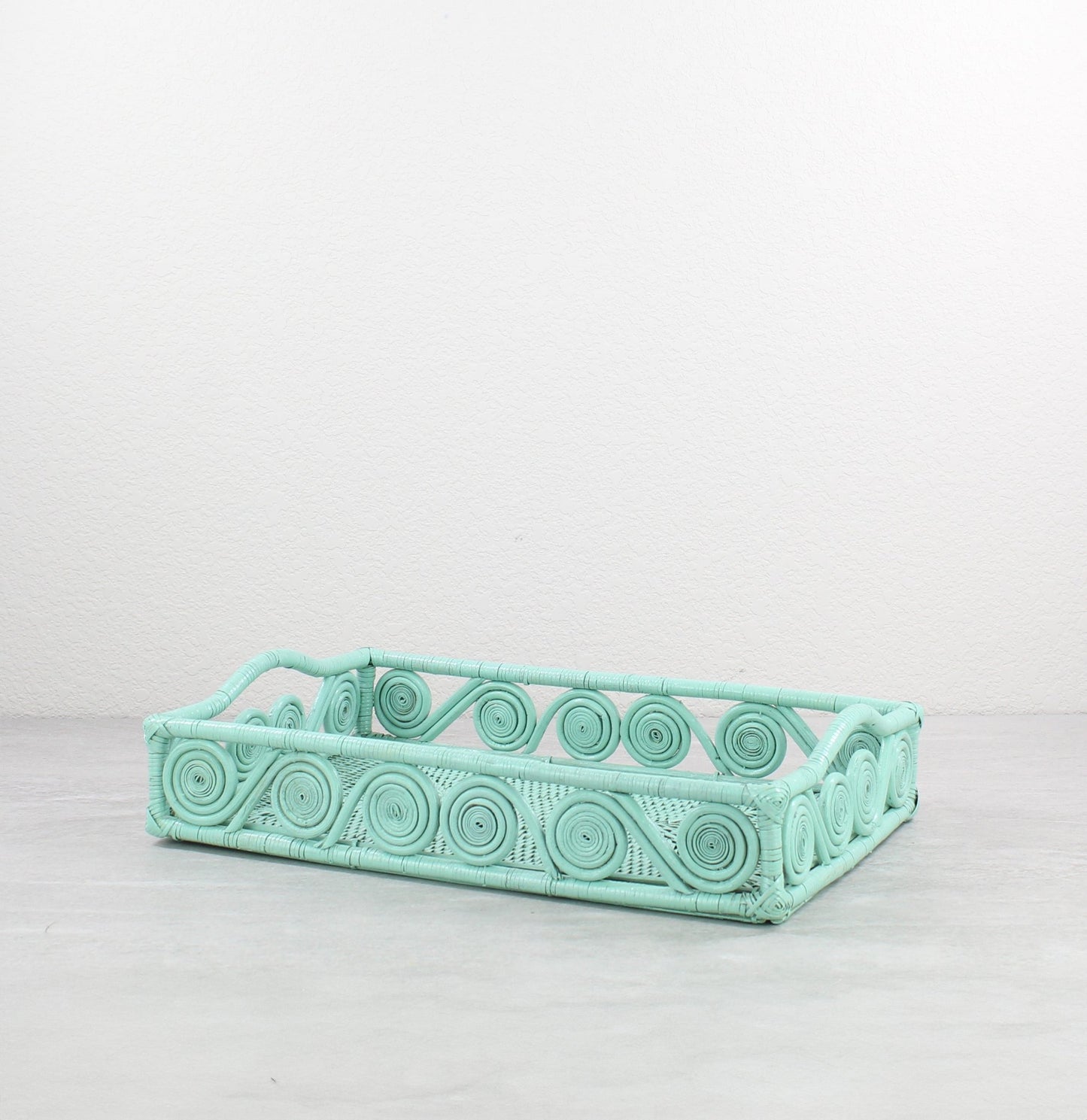 Small swirly rectangle rattan tray in sage leaf green, tight-woven with handles, shown on white background for product display