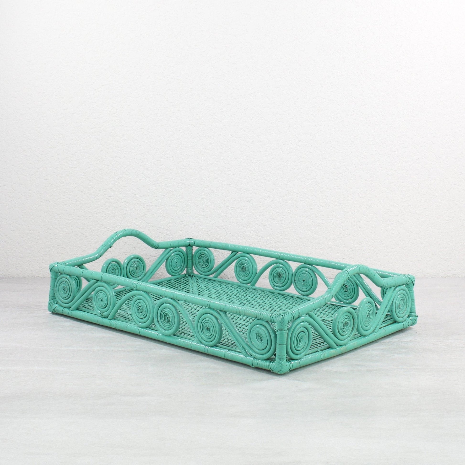 Rectangular turquoise rattan tray with swirl pattern sides and curved handle edges on both ends