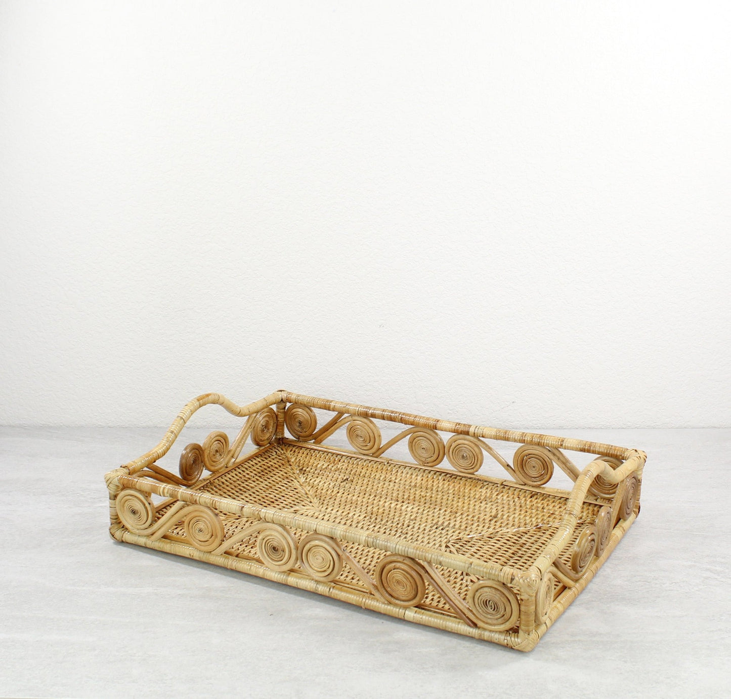Small swirly rectangle rattan tray in natural color, tight-woven with handles, shown on white background for product display
