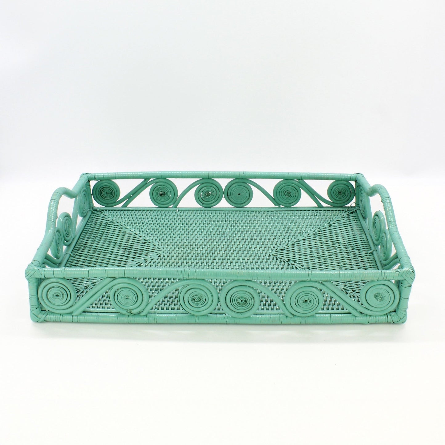 Empty turquoise rectangle rattan tray with swirl design and raised handles, handmade for serving or home décor, front view.