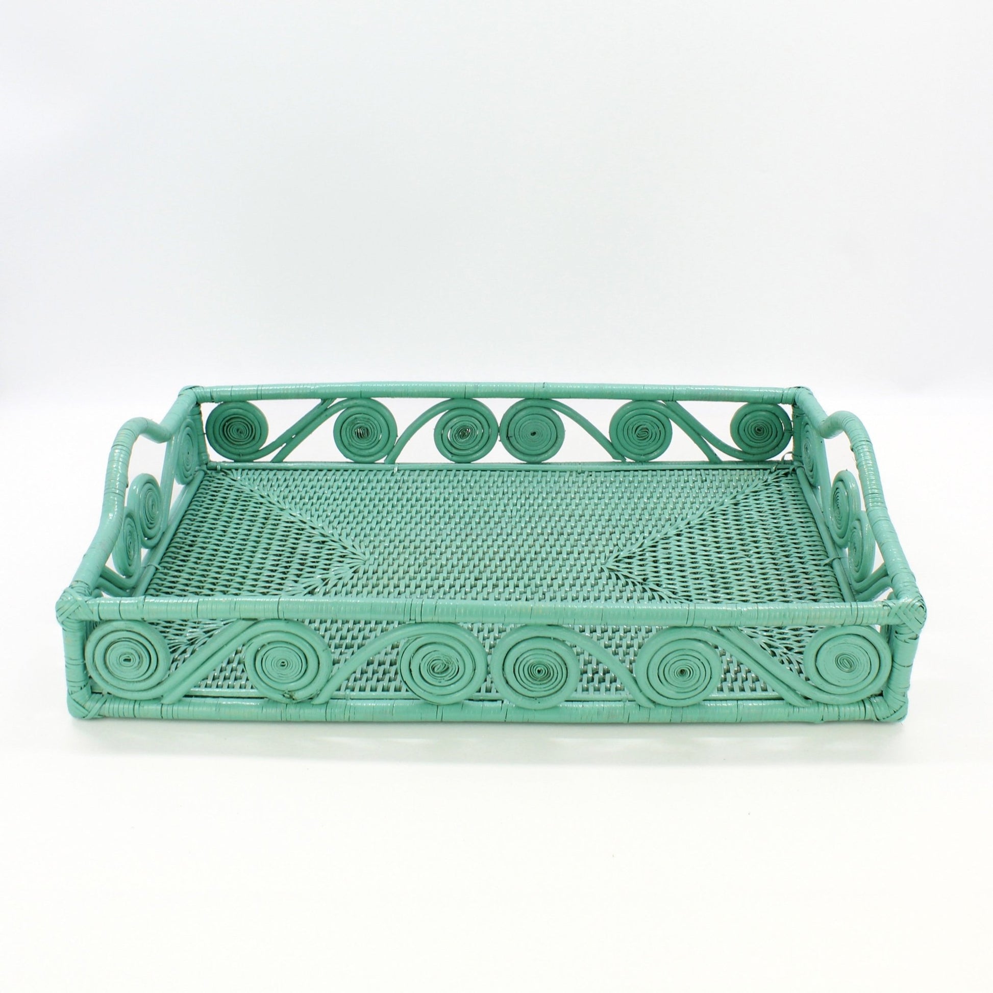 Empty turquoise rectangle rattan tray with swirl design and raised handles, handmade for serving or home décor, front view.