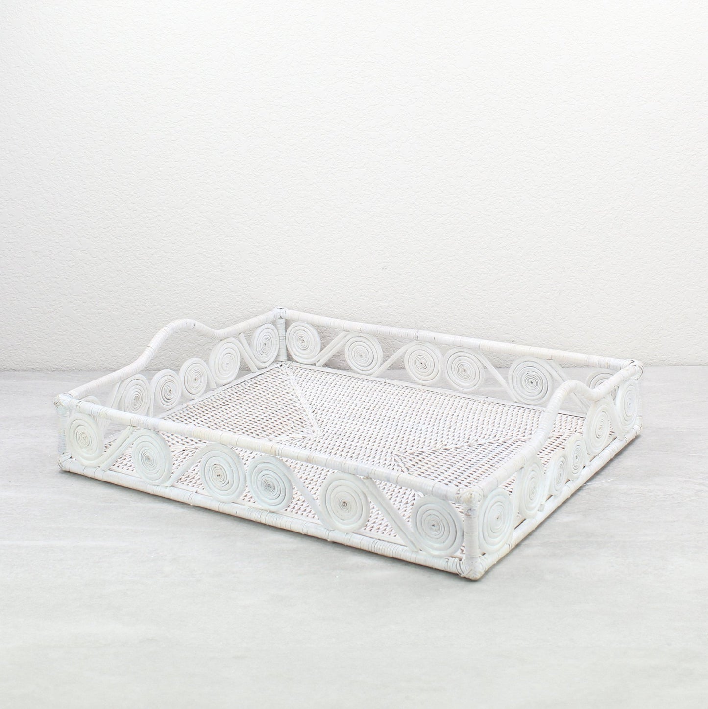 Whitewash rectangular rattan tray with swirl design and raised handles, handmade in a whitewash finish for serving, organizing, or home décor.
