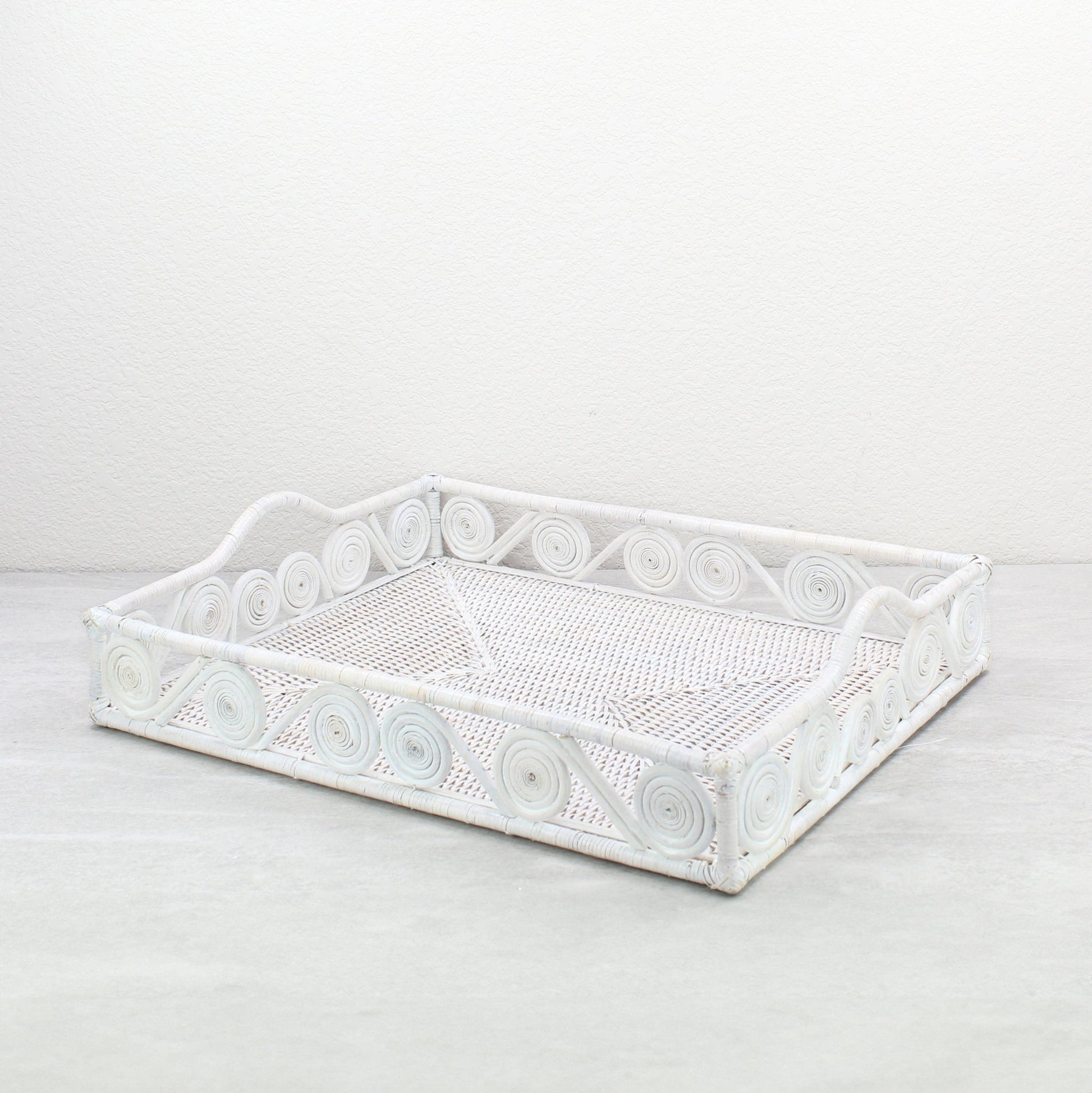 Whitewash rectangular rattan tray with swirl design and raised handles, handmade in a whitewash finish for serving, organizing, or home décor.