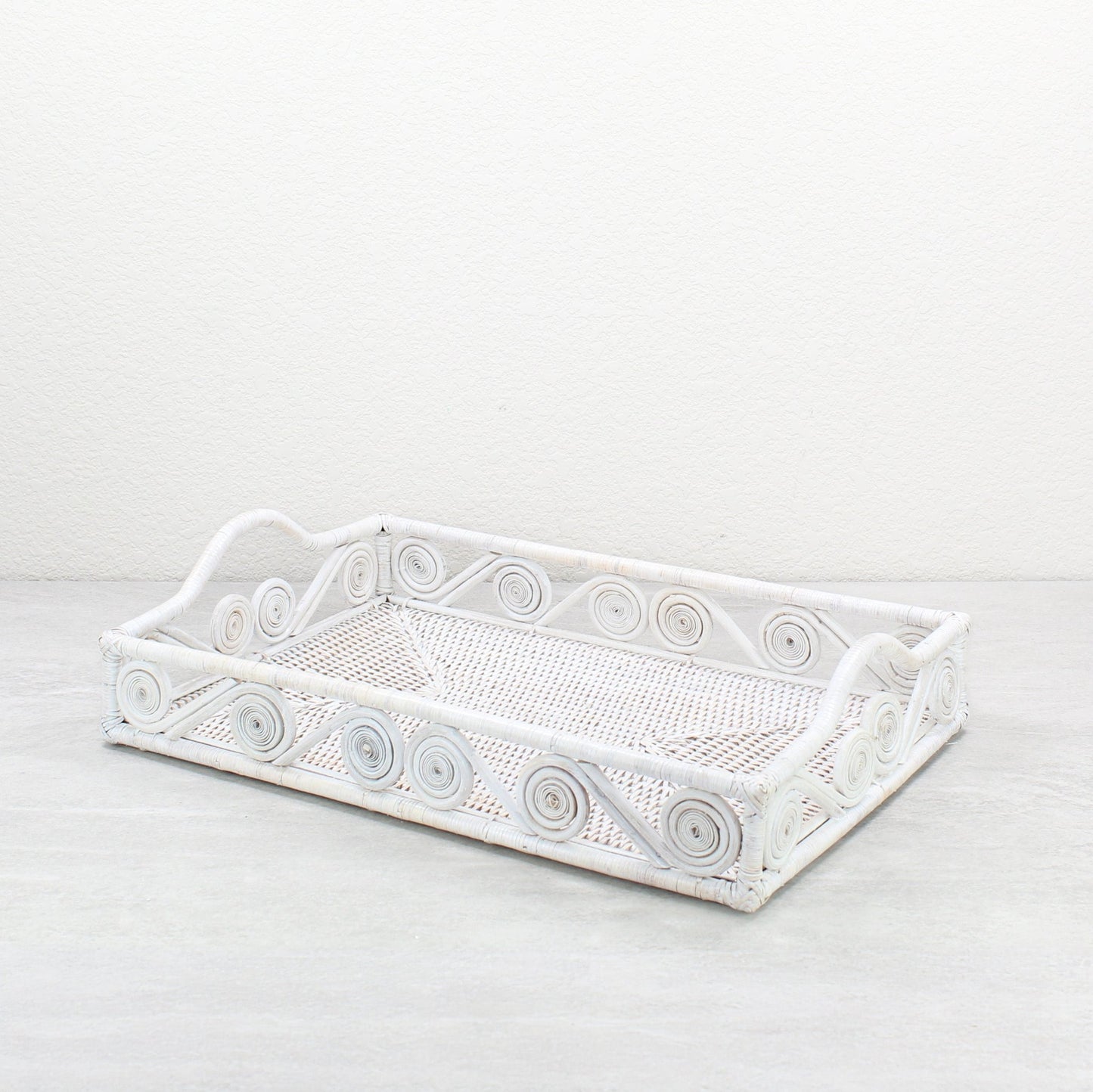 Whitewash rectangular rattan tray with swirl design and raised handles, handmade in a whitewash finish for serving, organizing, or home décor.