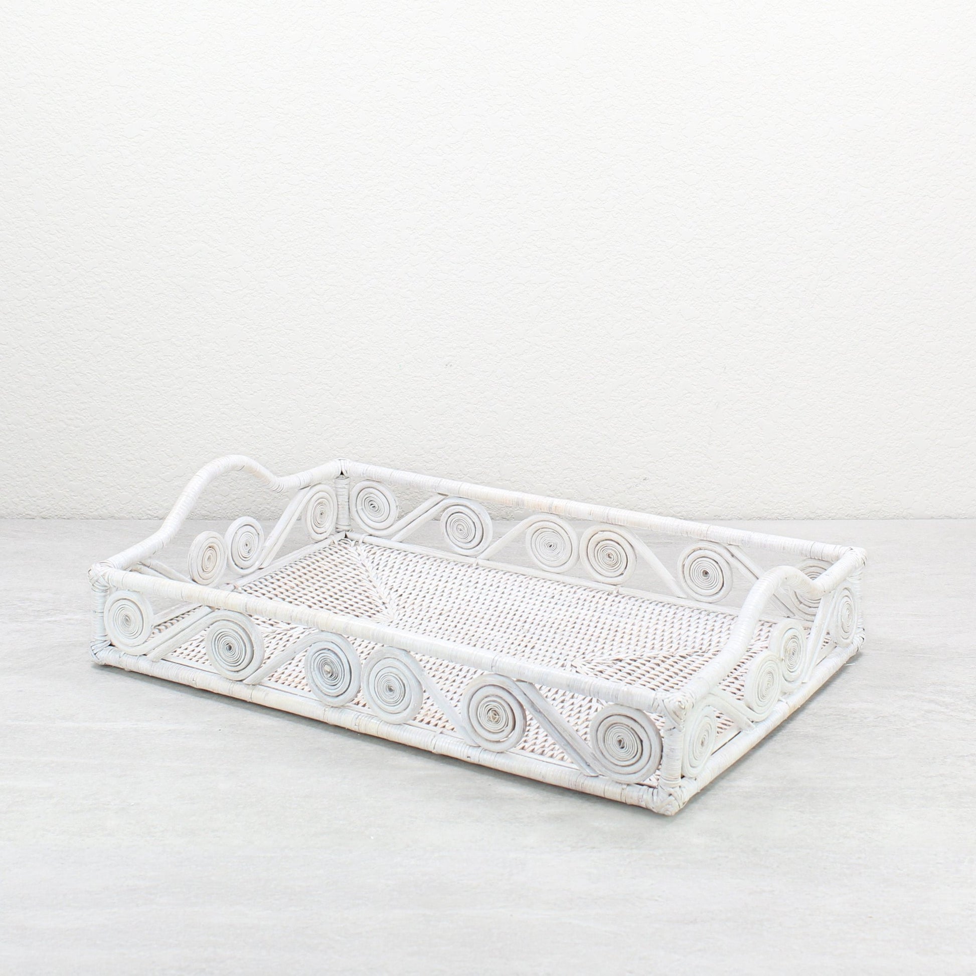 Whitewash rectangular rattan tray with swirl design and raised handles, handmade in a whitewash finish for serving, organizing, or home décor.