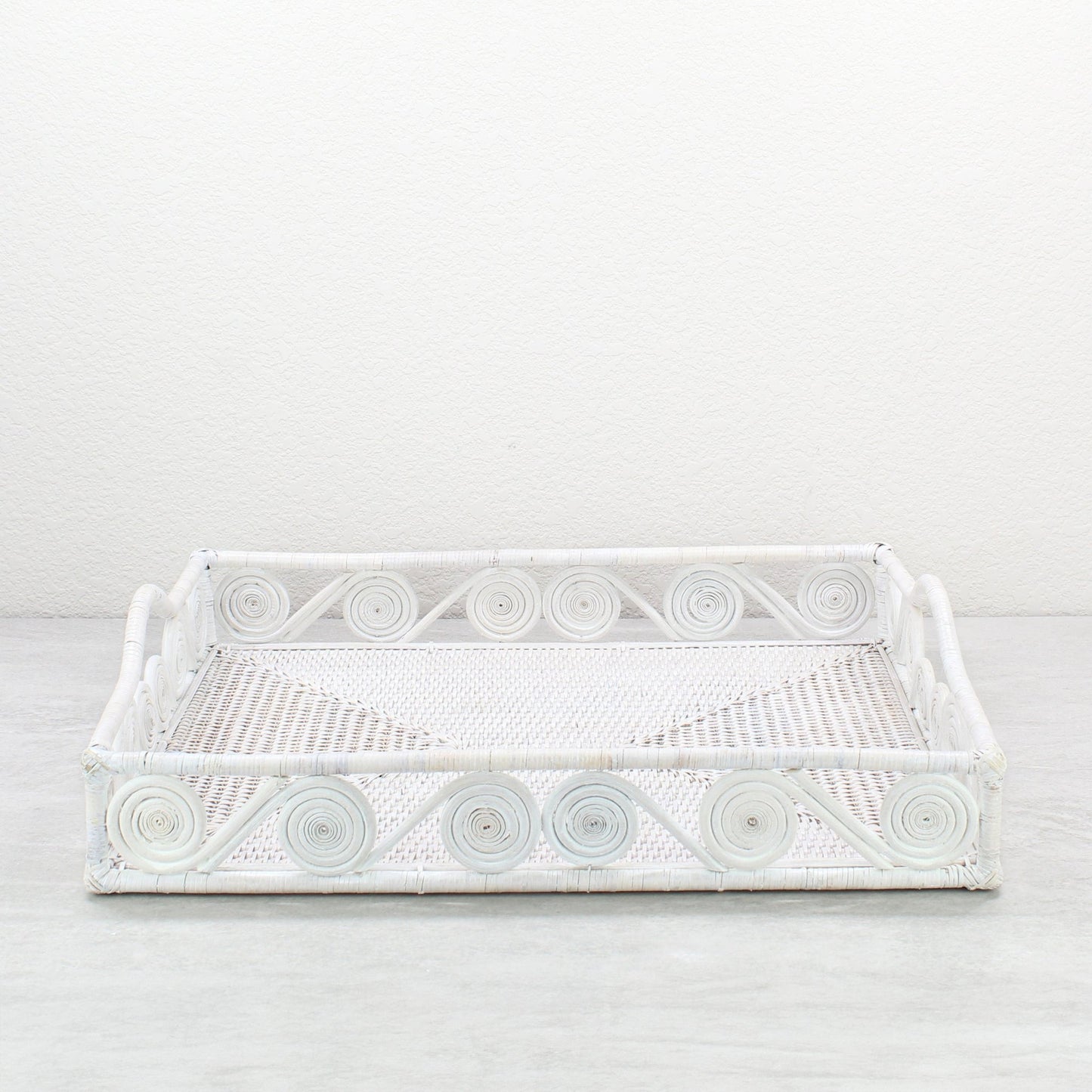 Whitewash rectangular rattan tray with swirl edge design, handmade for serving, organizing, or modern home décor styling, front view.